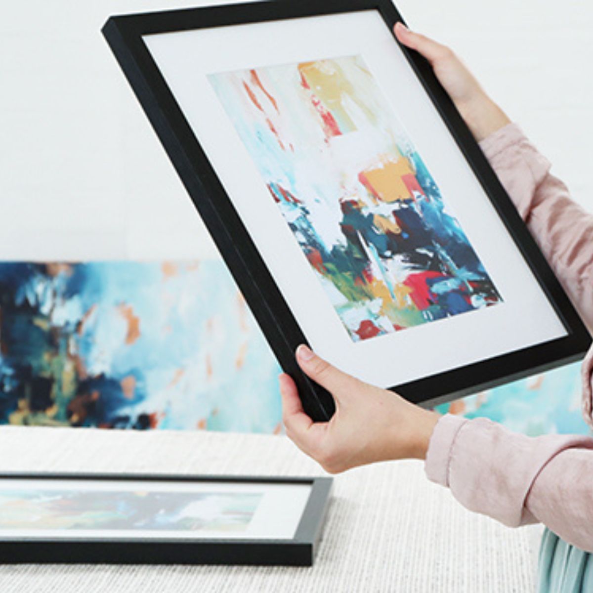 woman holding a framed artwork