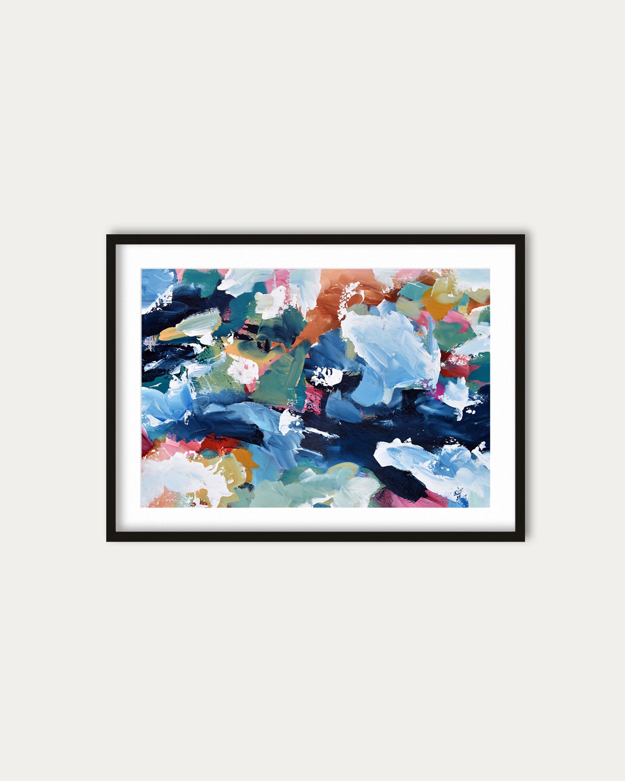 Framed abstract artwork with colorful brush strokes on a white wall
