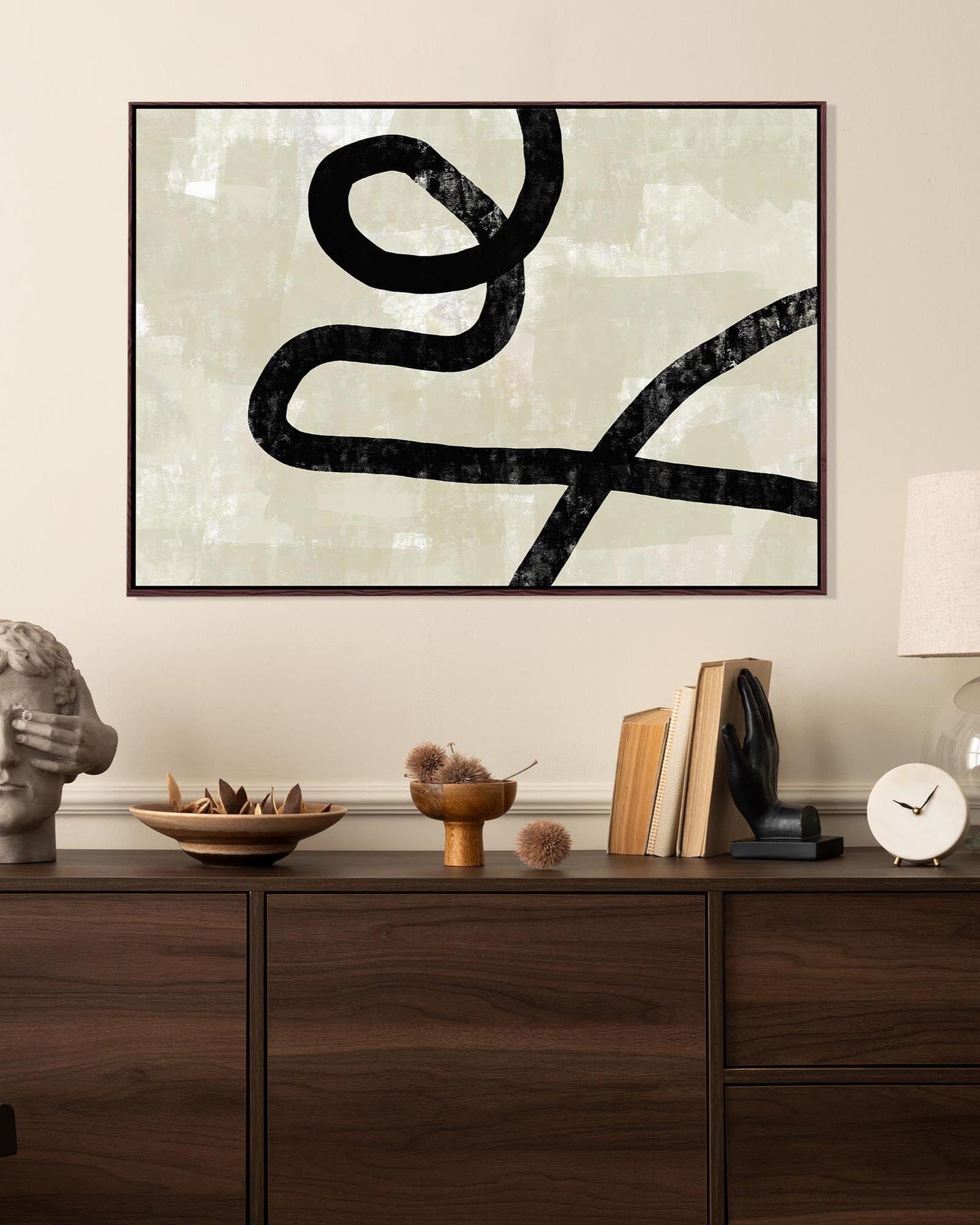 Abstract black line art on a light background in a modern interior setting.