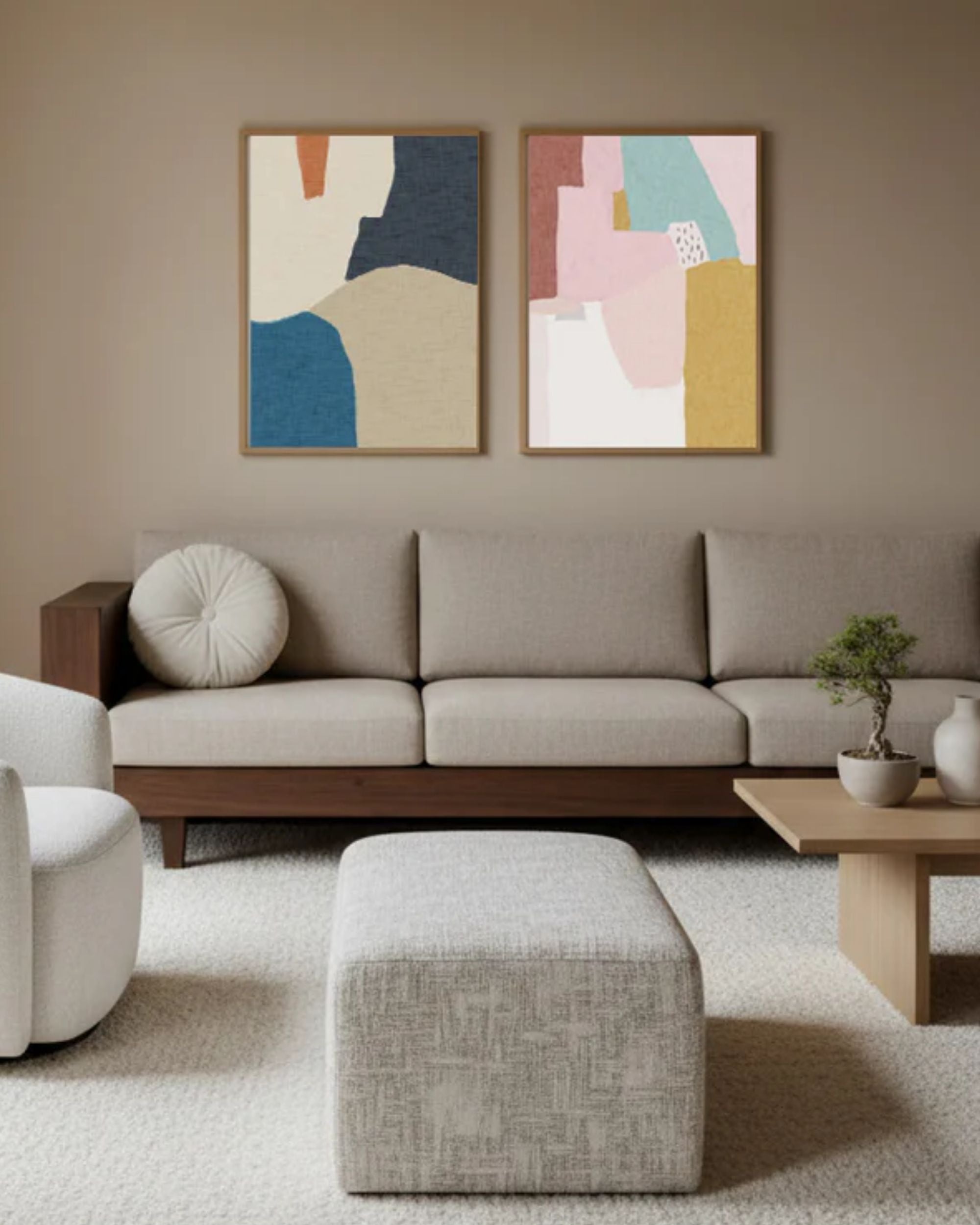 Modern living room with a grey sofa, white armchair, and abstract wall art.