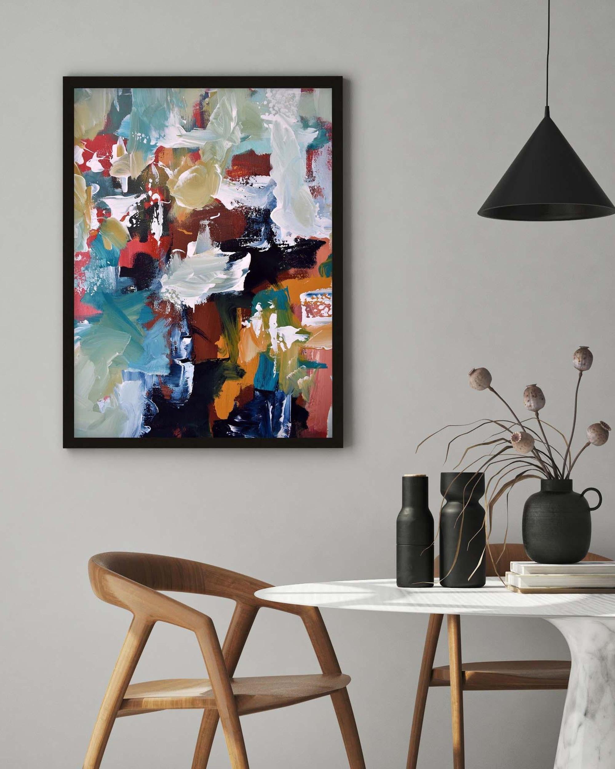 Abstract painting on a wall above a table with decorative items.