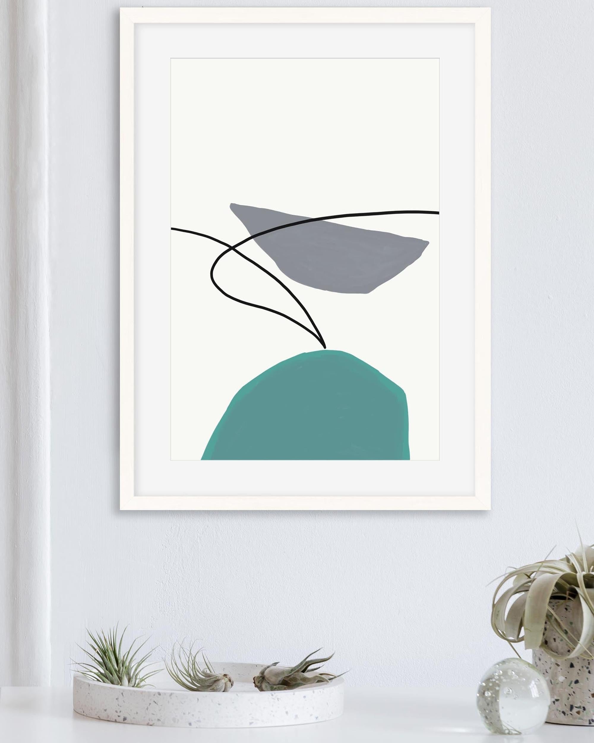 Framed abstract art print with geometric shapes on a white wall.