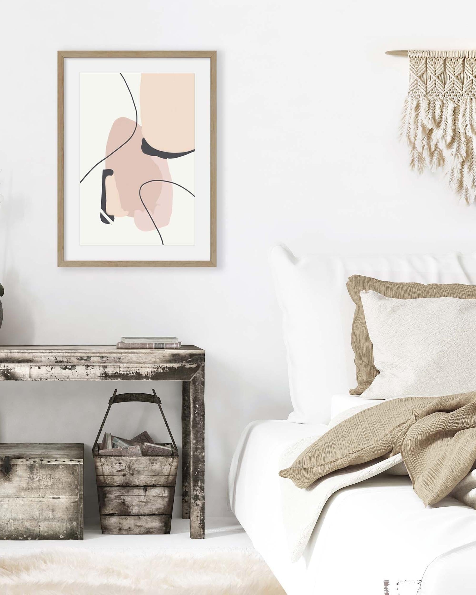 Modern bedroom with abstract art on the wall, wooden console table, and bed with pillows and blanket.