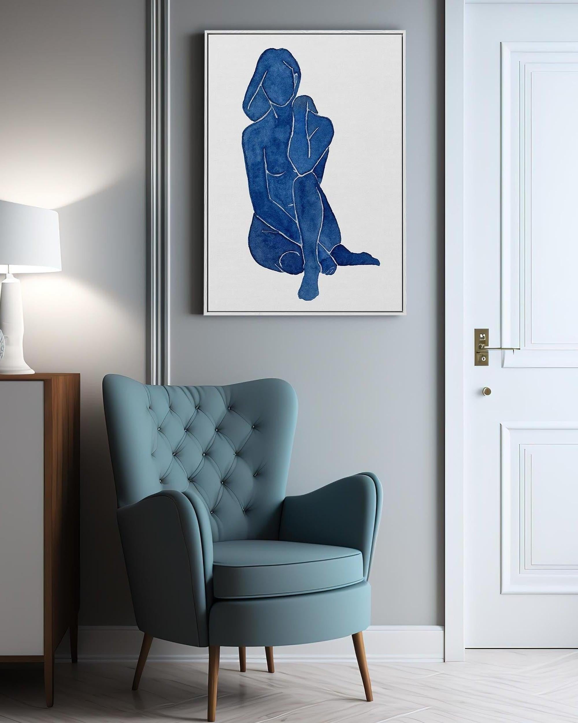 Blue armchair in a room with a framed abstract art piece on the wall.