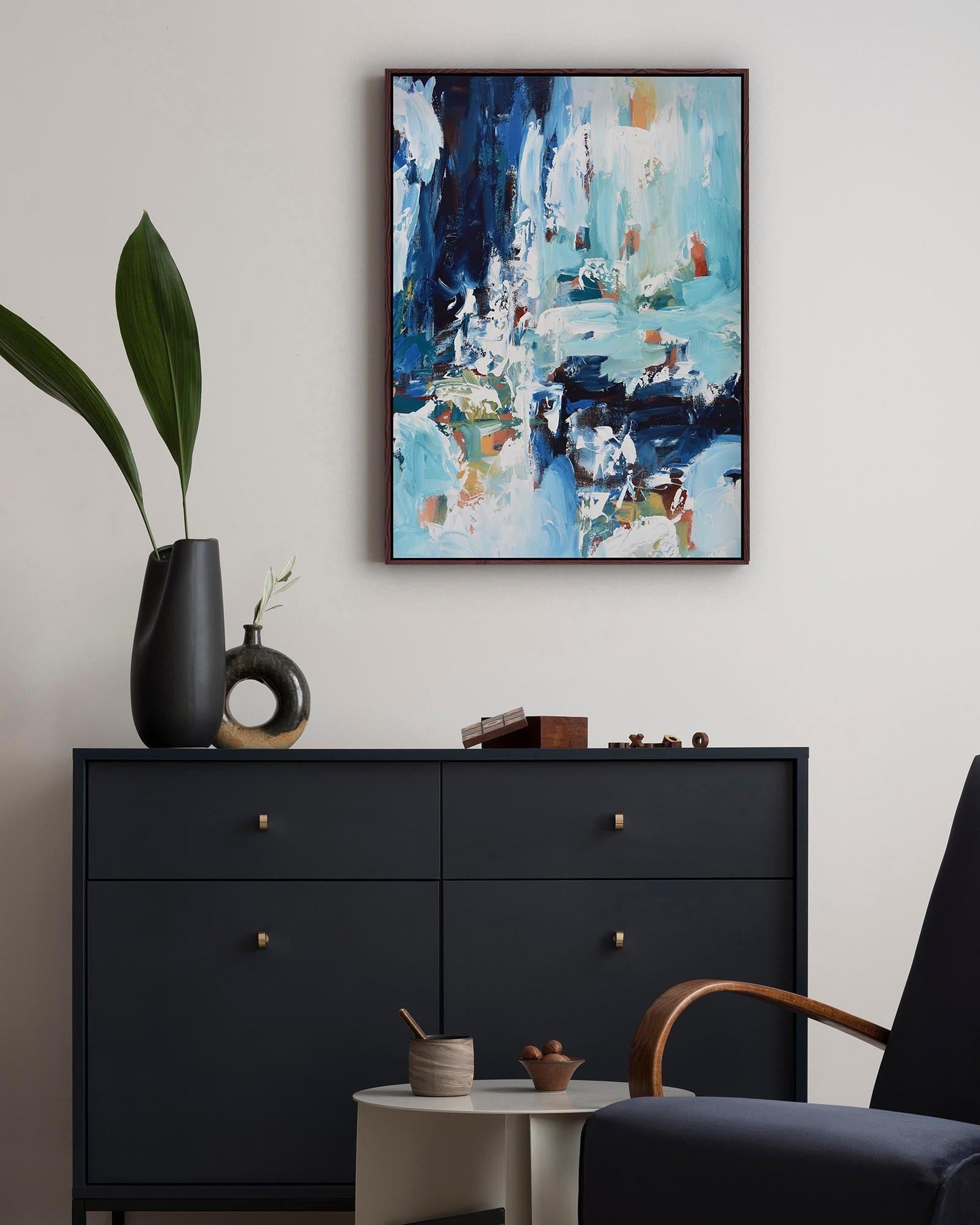 Modern interior with abstract painting, black dresser, and decorative items.