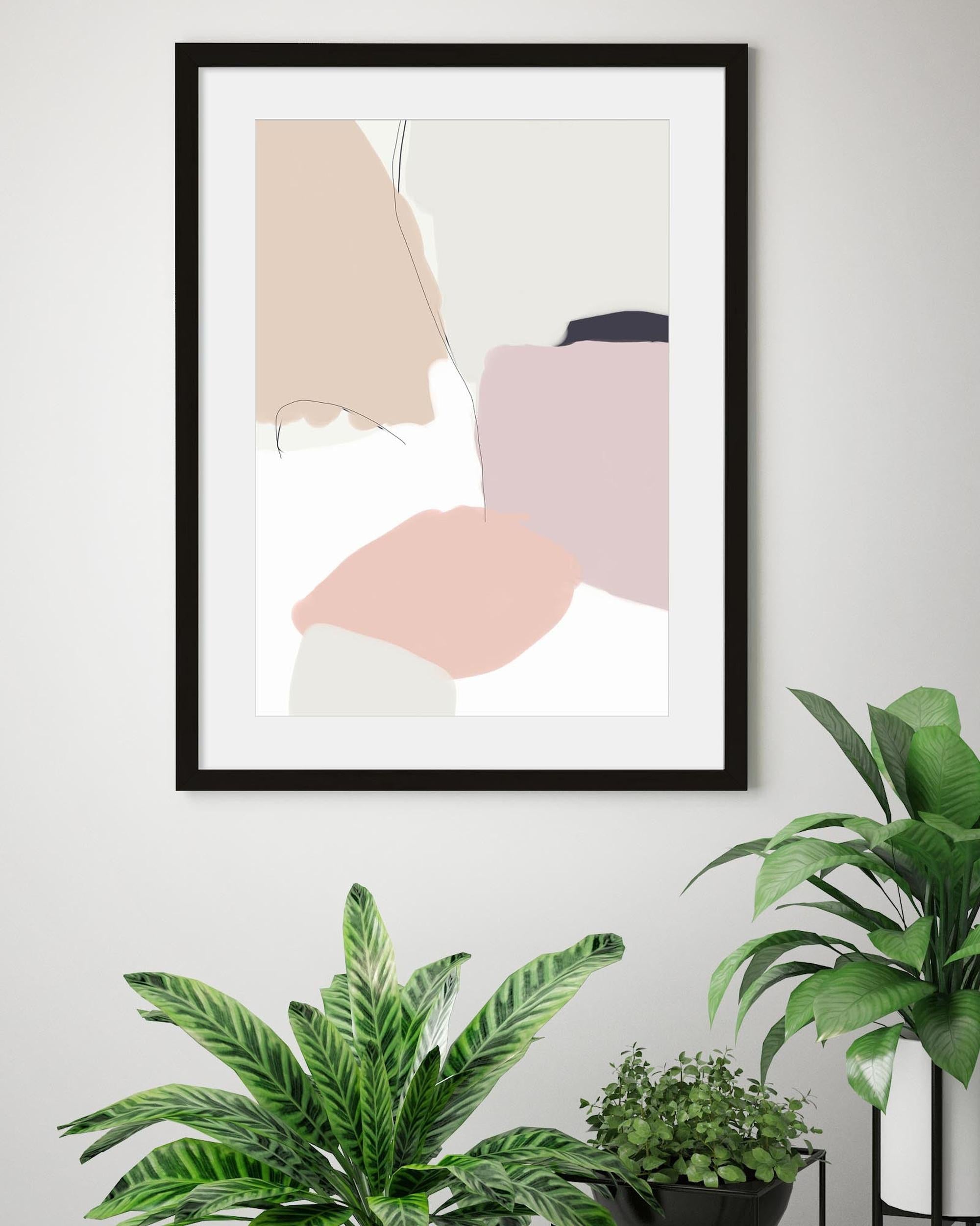 Framed abstract art on a wall with plants below