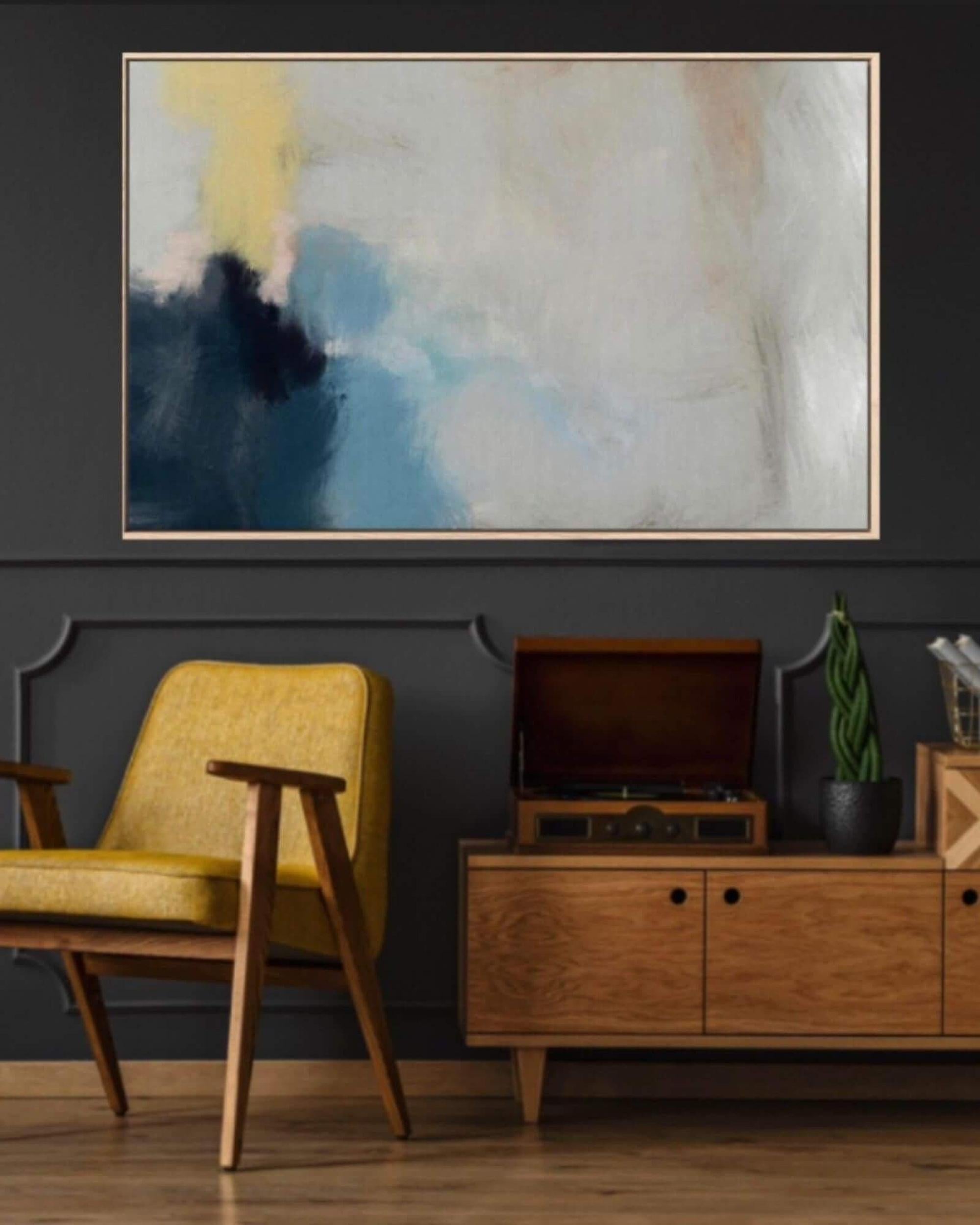 Living room with a yellow armchair, wooden cabinet, and abstract painting on a dark wall.