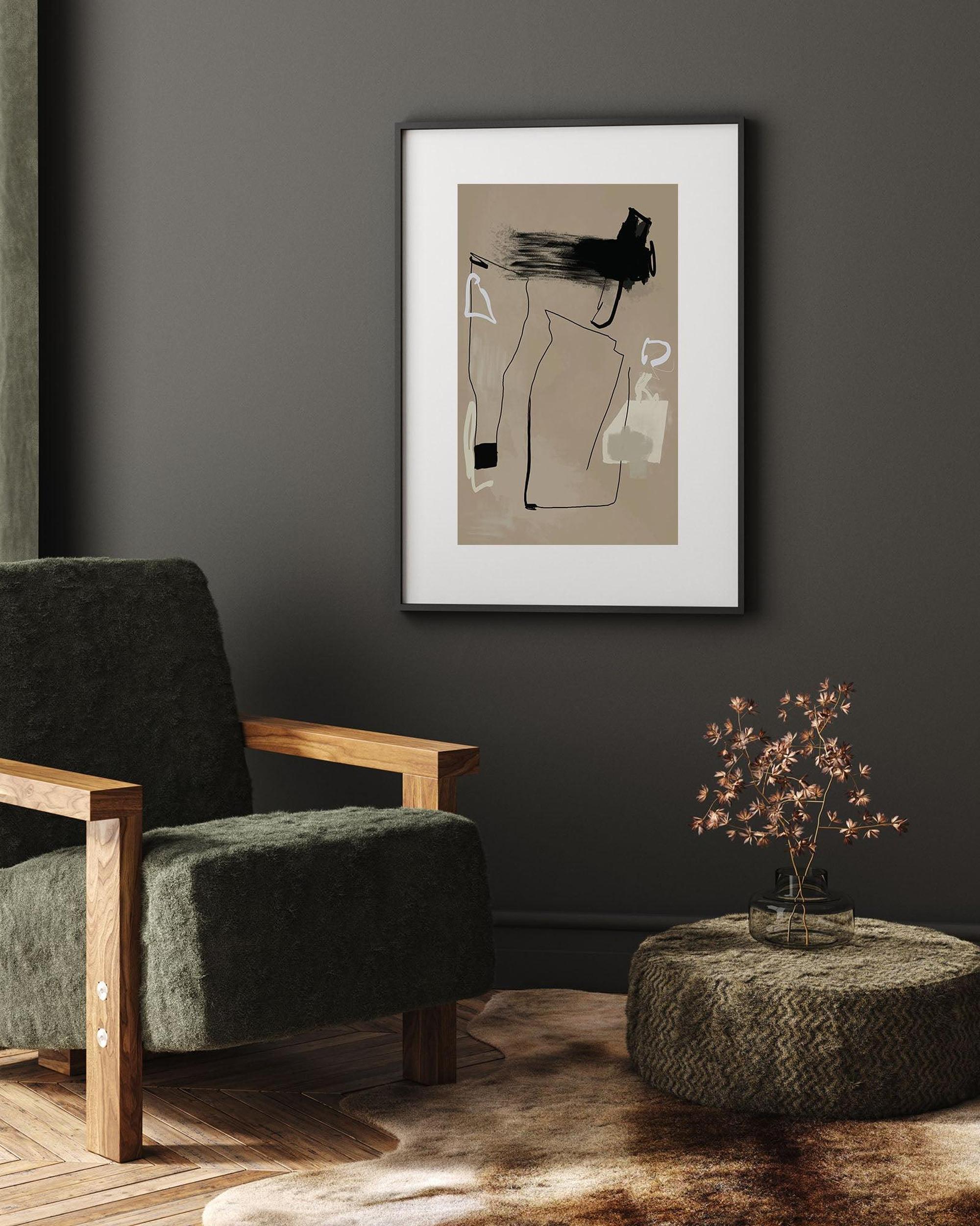 Framed abstract art on a dark wall above a green armchair.