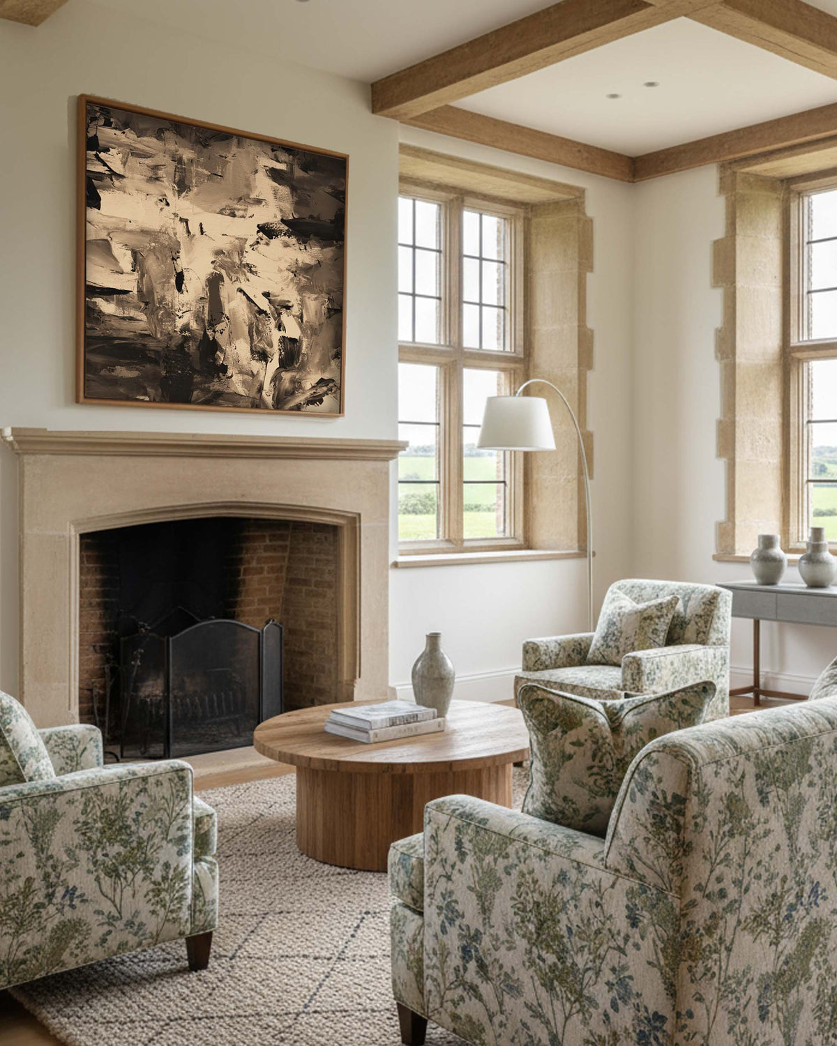Living room with floral armchairs, a fireplace, and large windows.