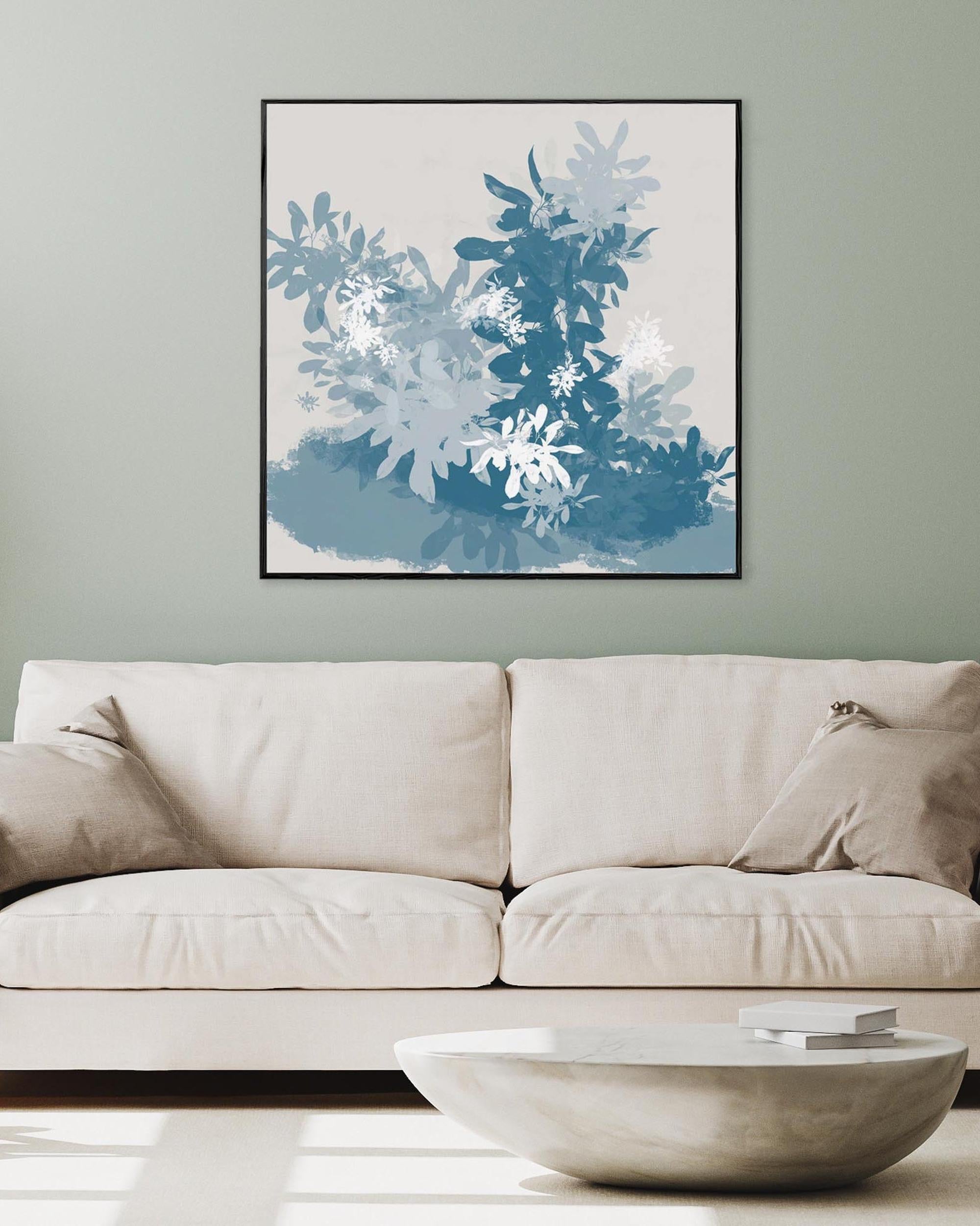 Beige sofa with a modern abstract painting above it on a light gray wall.