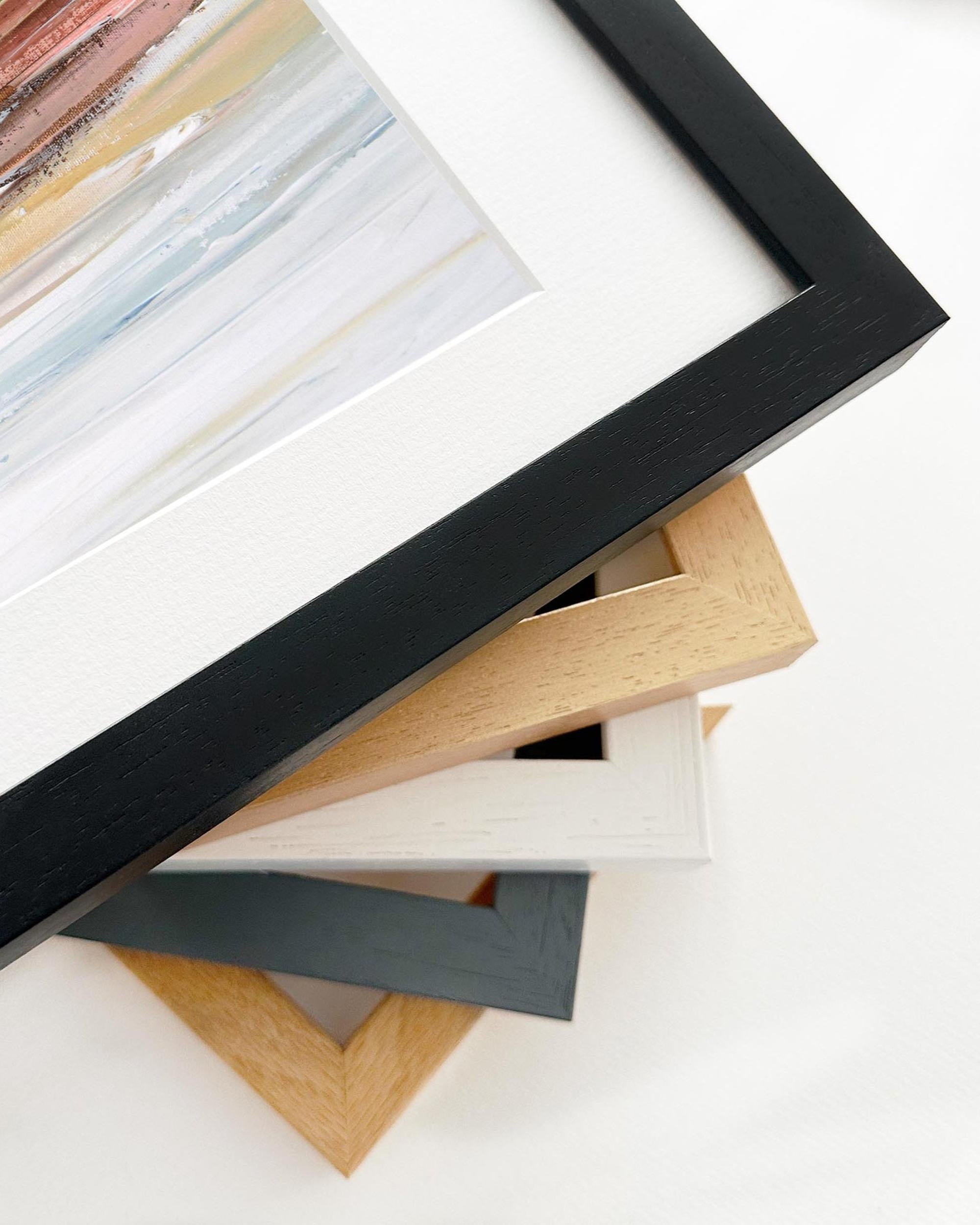 Stack of variously colored picture frames on a white background
