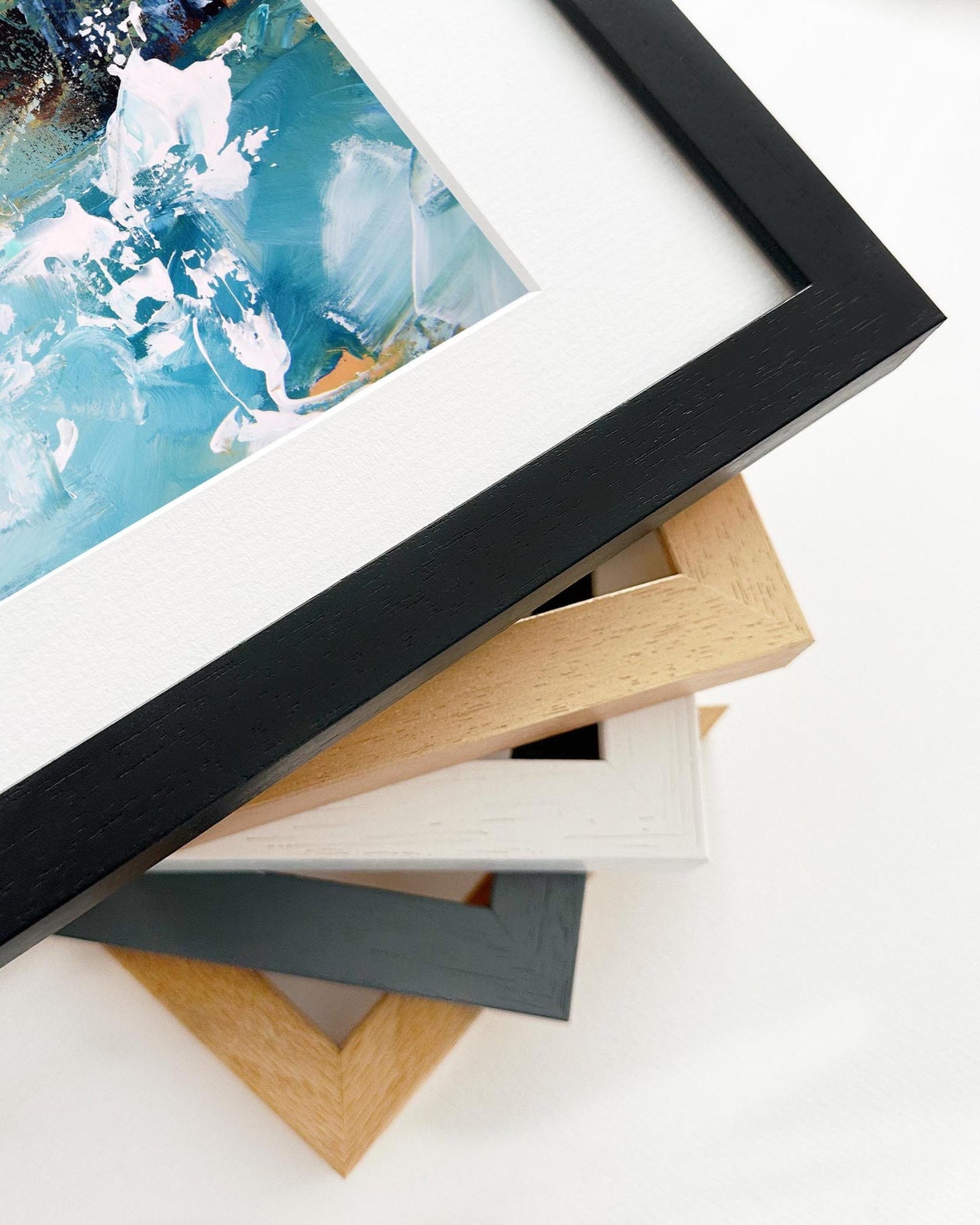 Stack of variously colored picture frames on a white surface