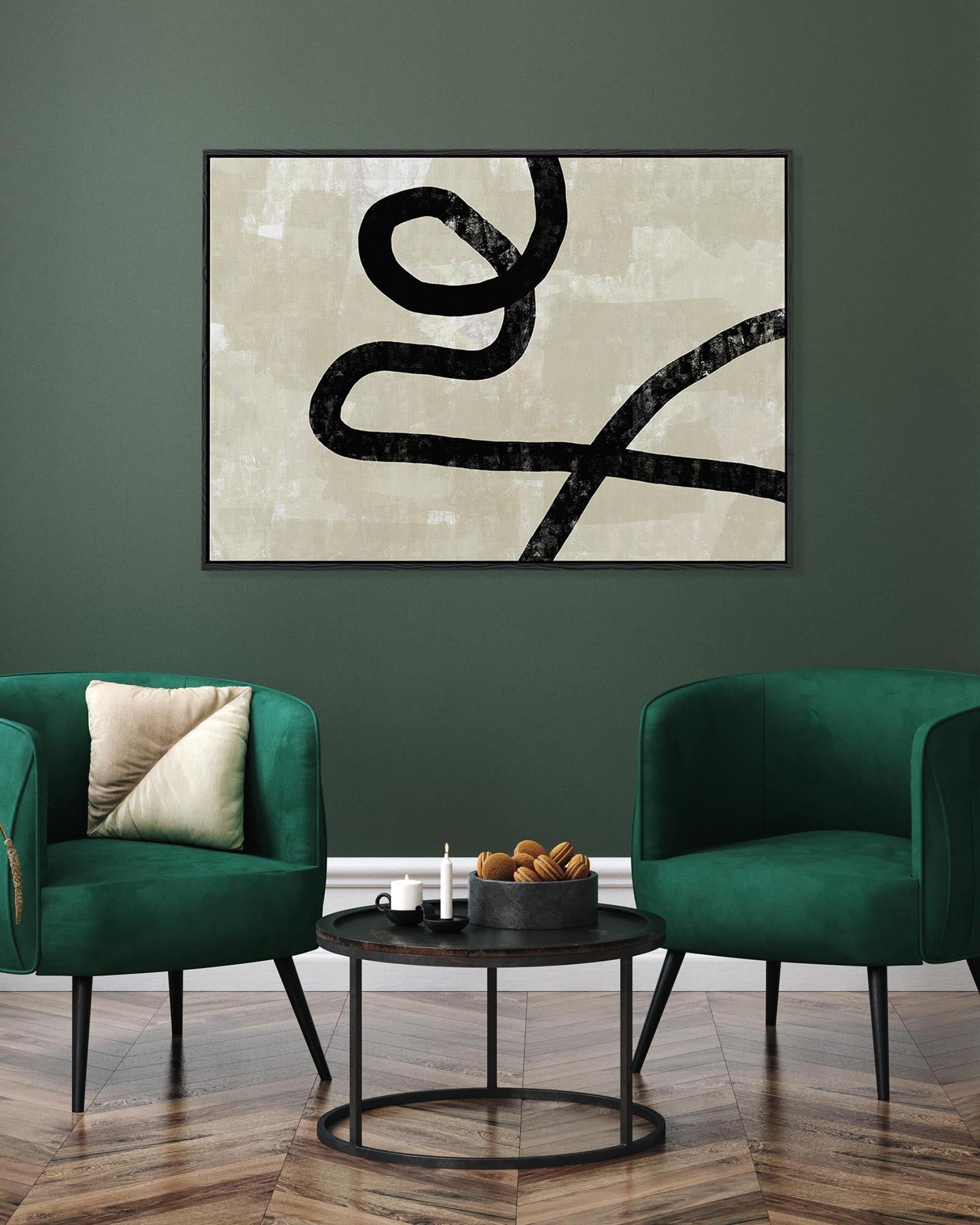 Abstract artwork on a wall above two green chairs in a room.