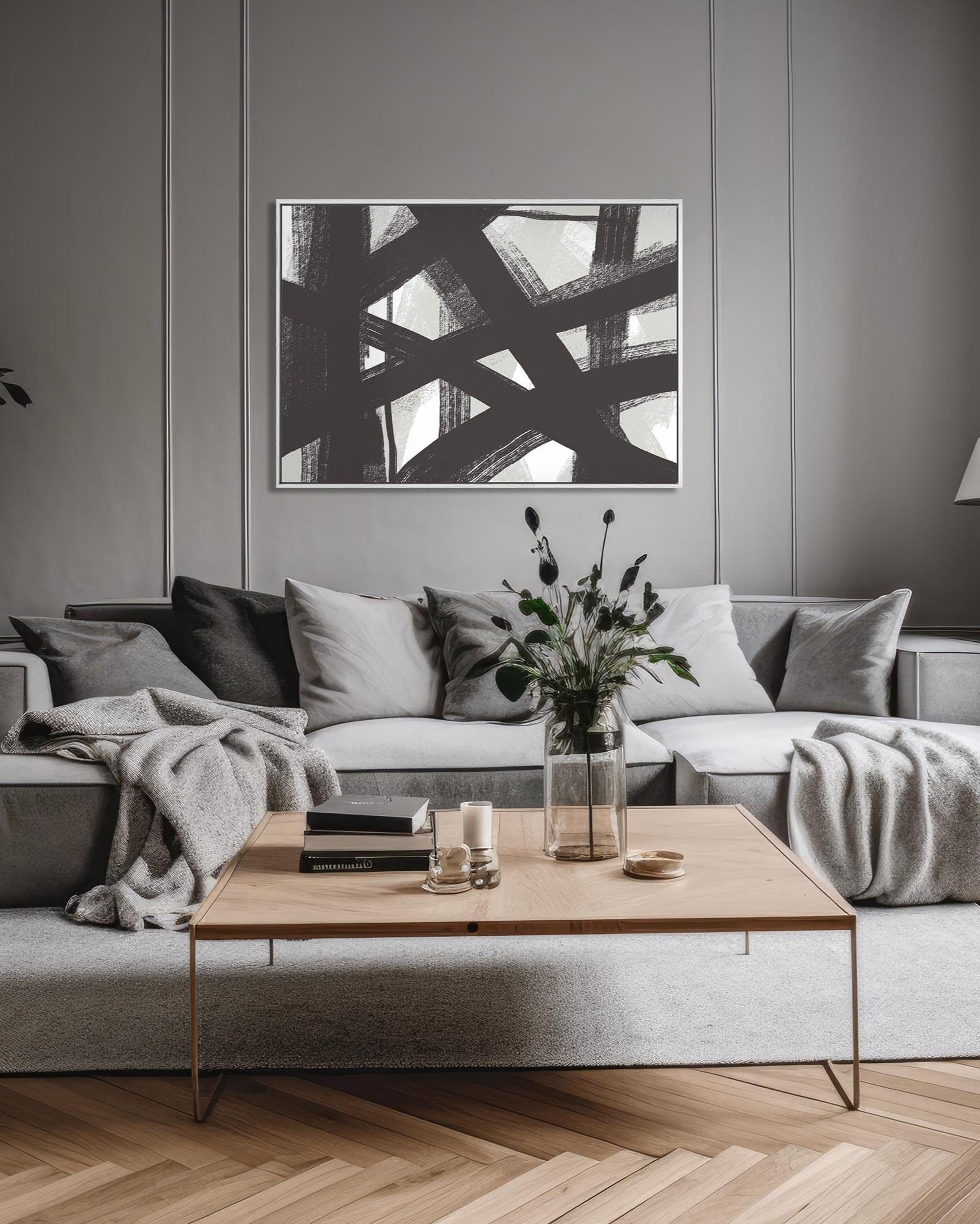 Modern living room with a gray sofa, wooden coffee table, and abstract art on the wall.