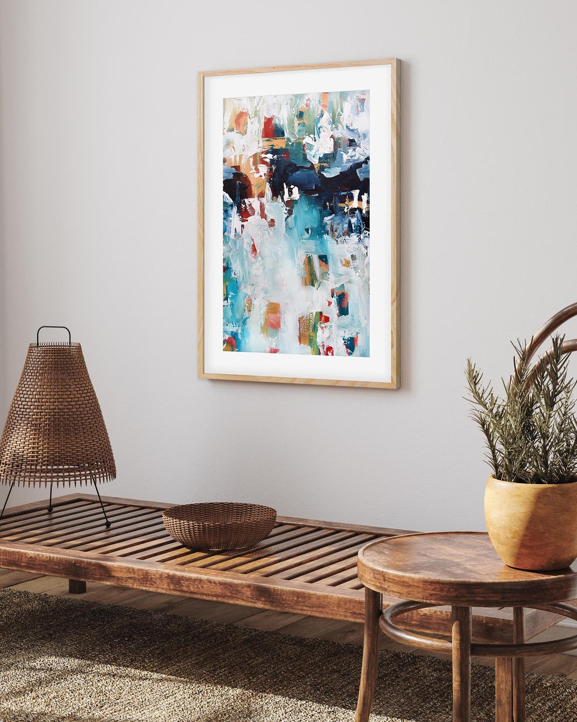 Living room with wooden bench, round table, and abstract art on the wall.