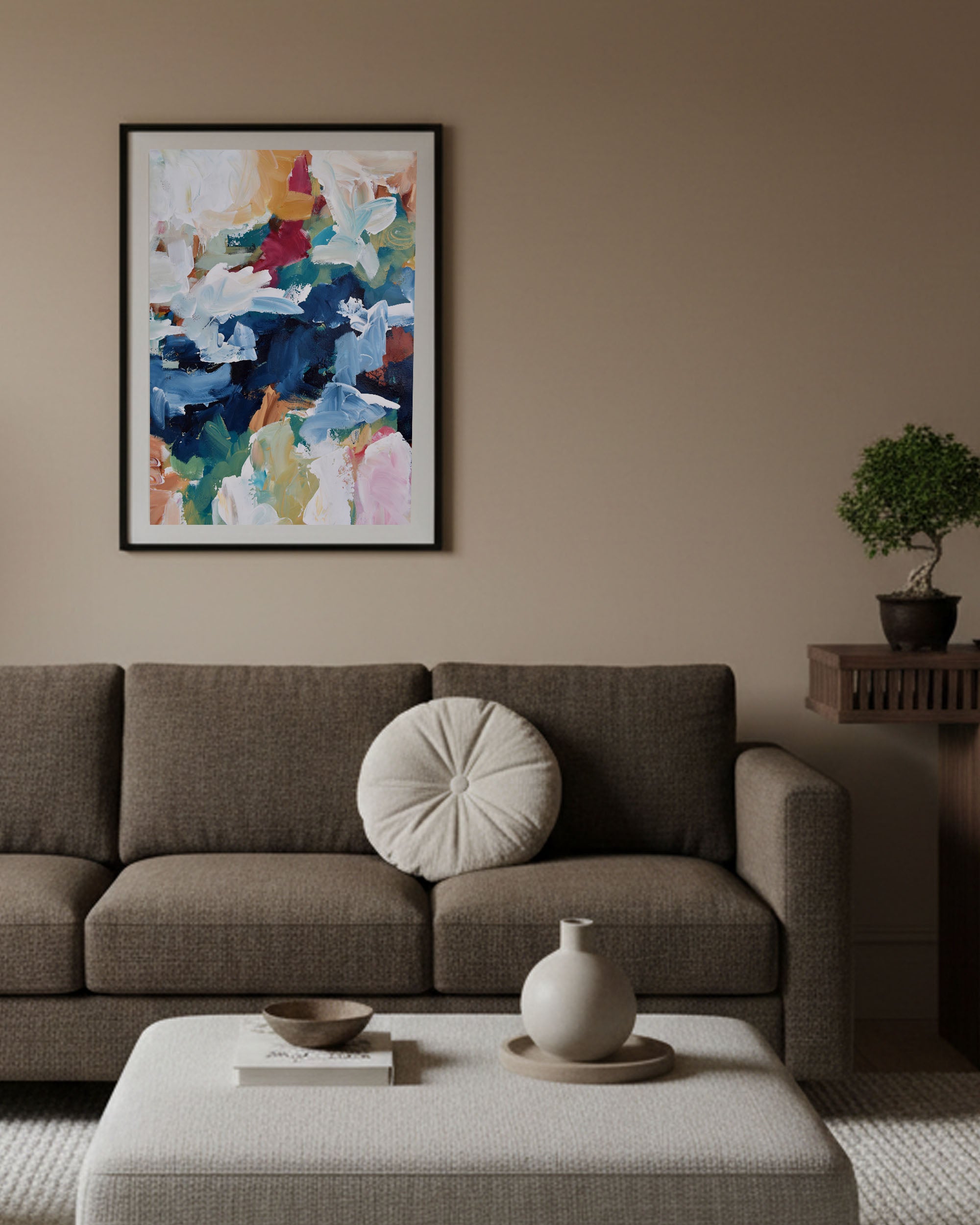 Living room with a brown sofa, abstract art on the wall, and decorative items.