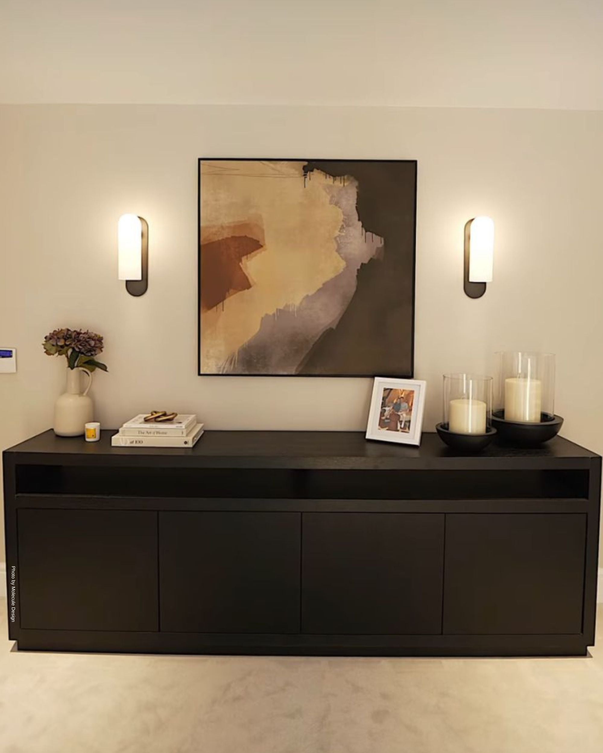 Modern living room with a black sideboard, wall art, and decor.