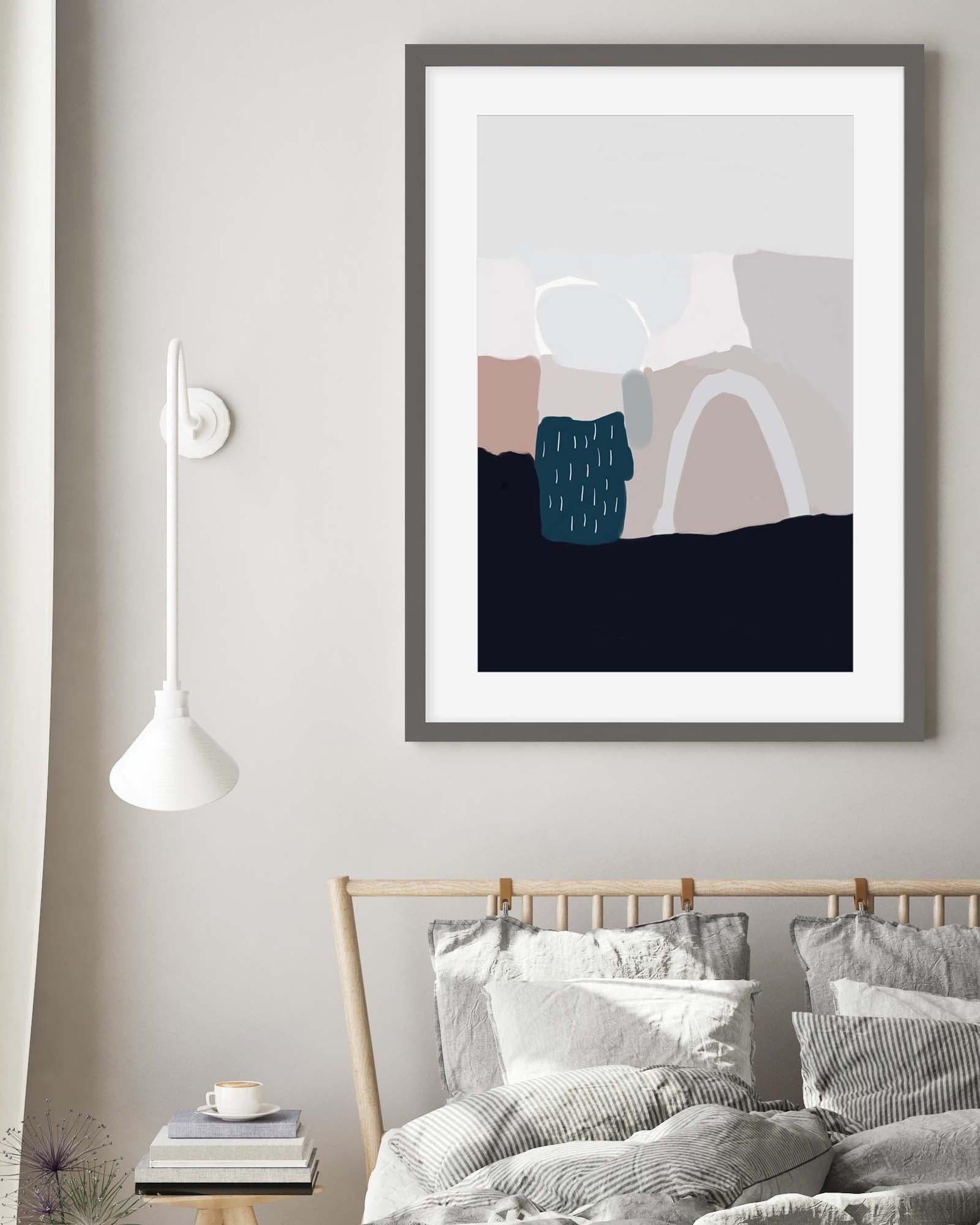 Framed abstract art piece on a wall above a bed in a bedroom setting.