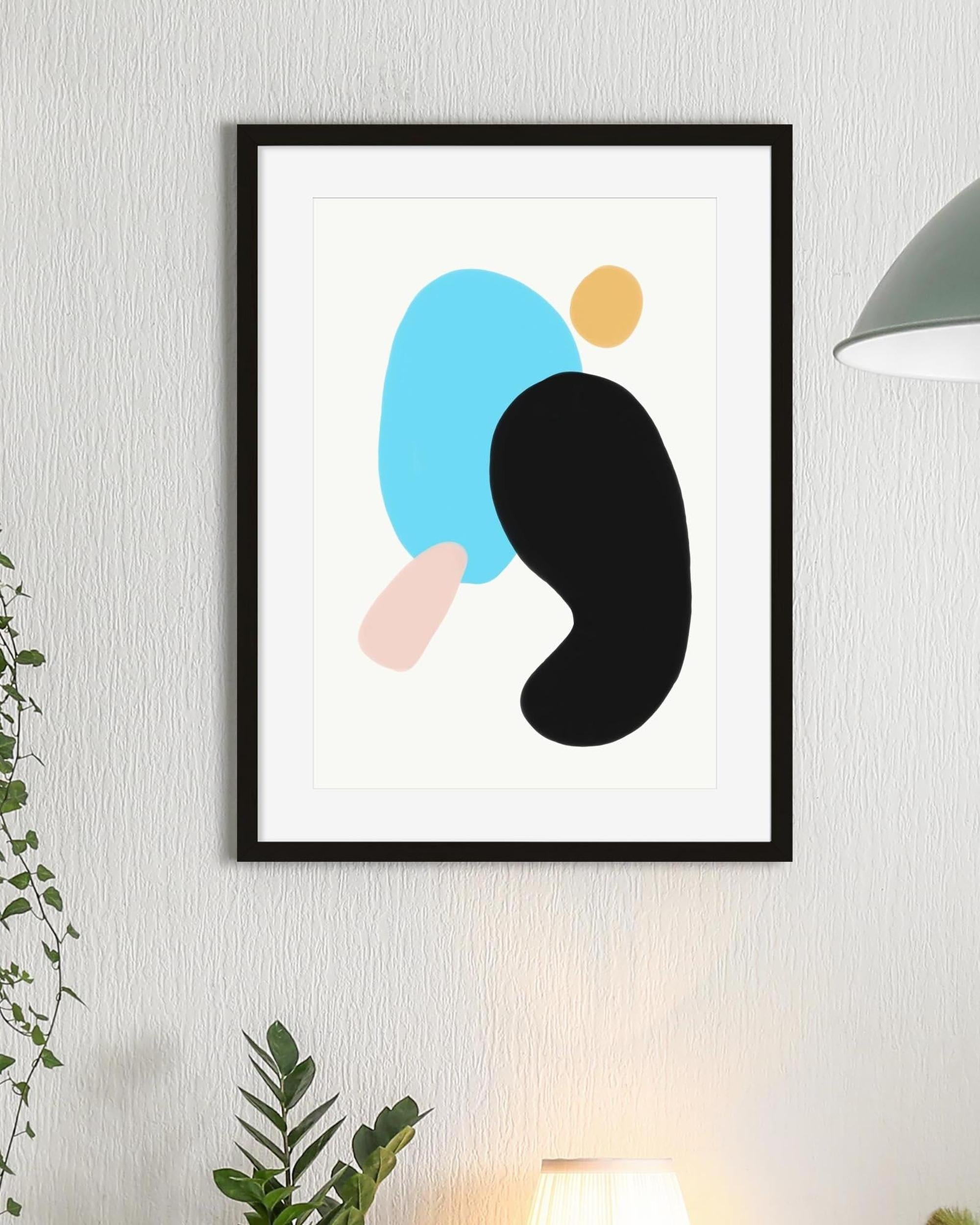 Framed abstract art print with colorful shapes on a wall.