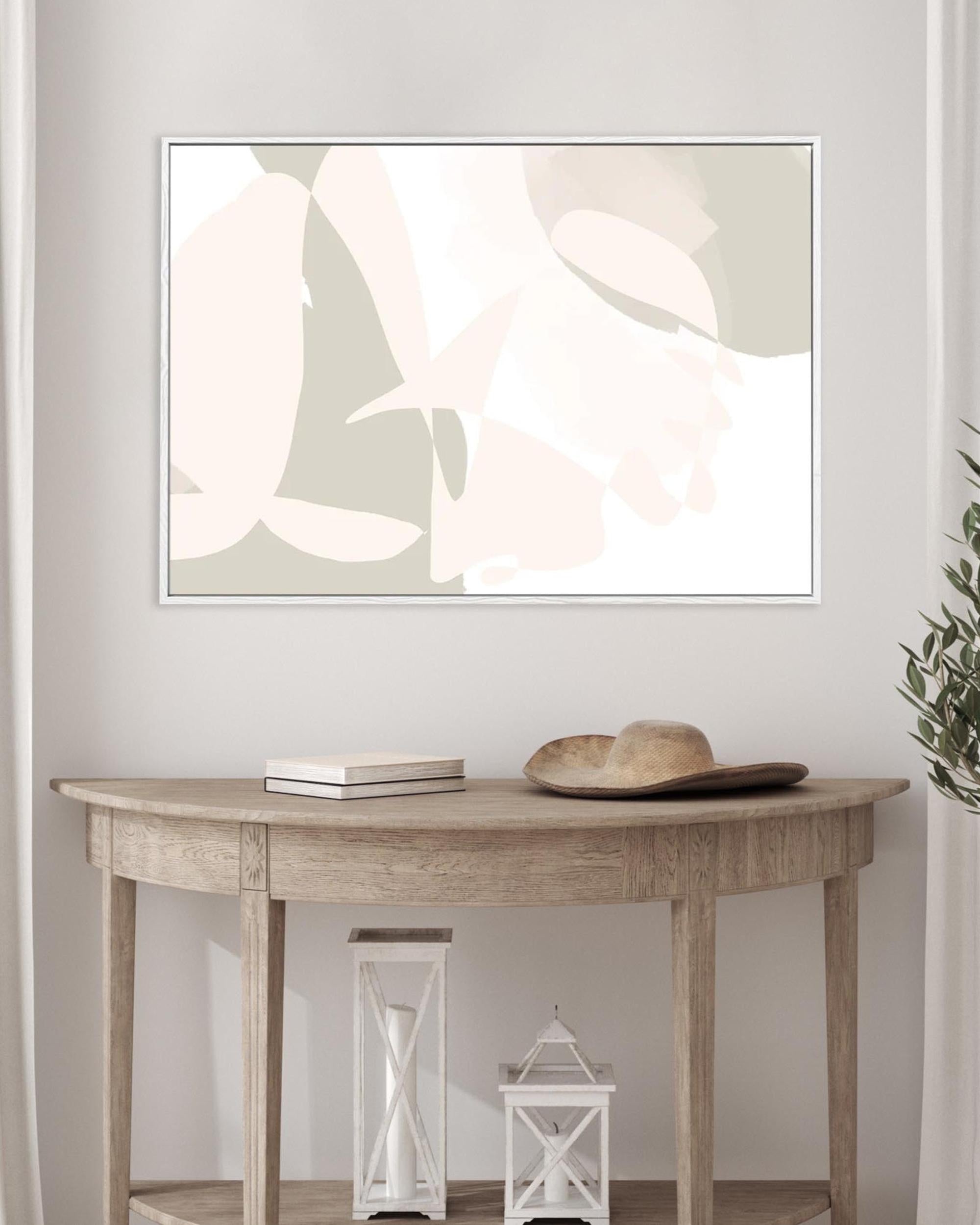 Framed abstract artwork on a wall above a wooden console table with decorative items.