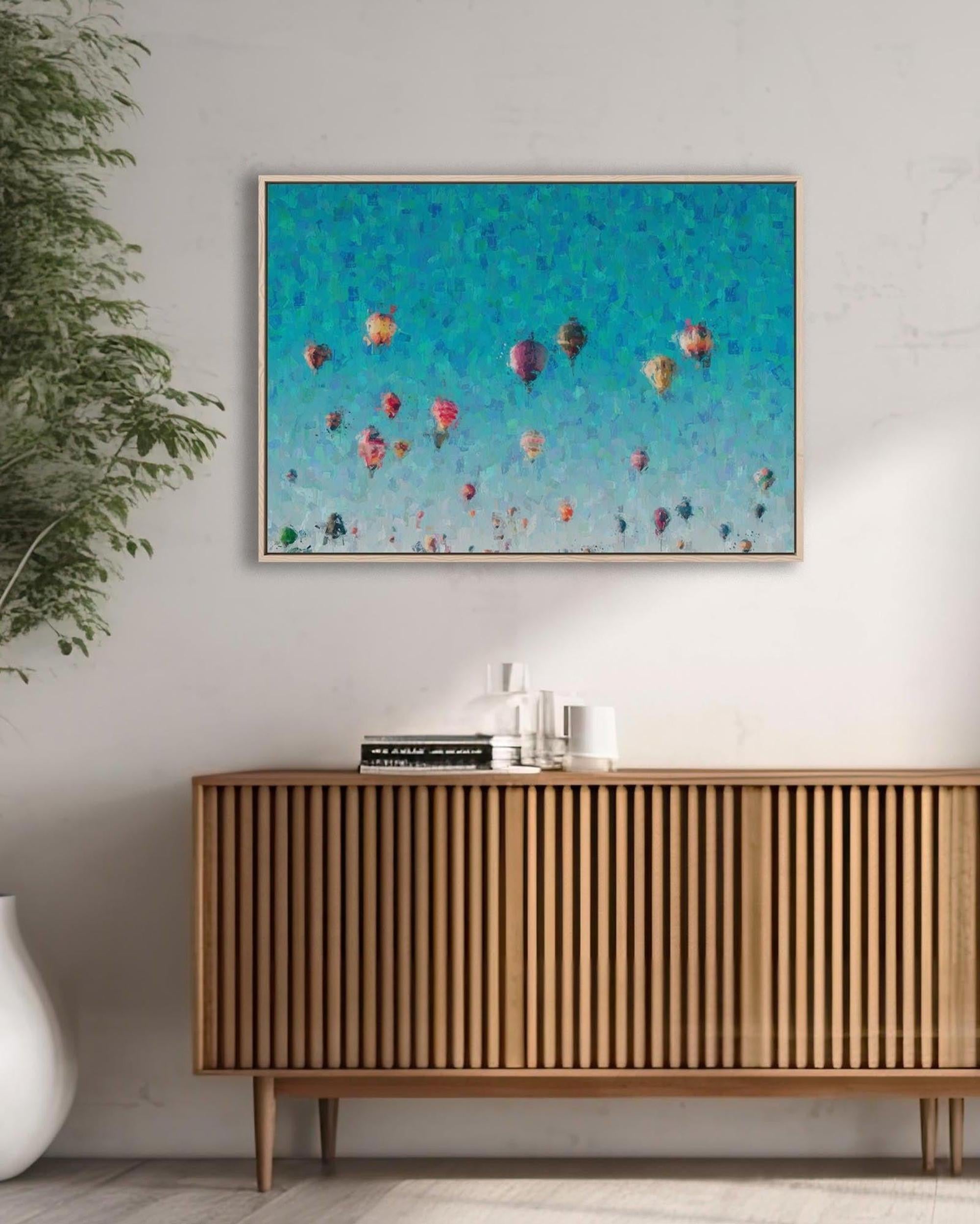 Framed artwork of colorful balloons on a wall above a wooden sideboard.