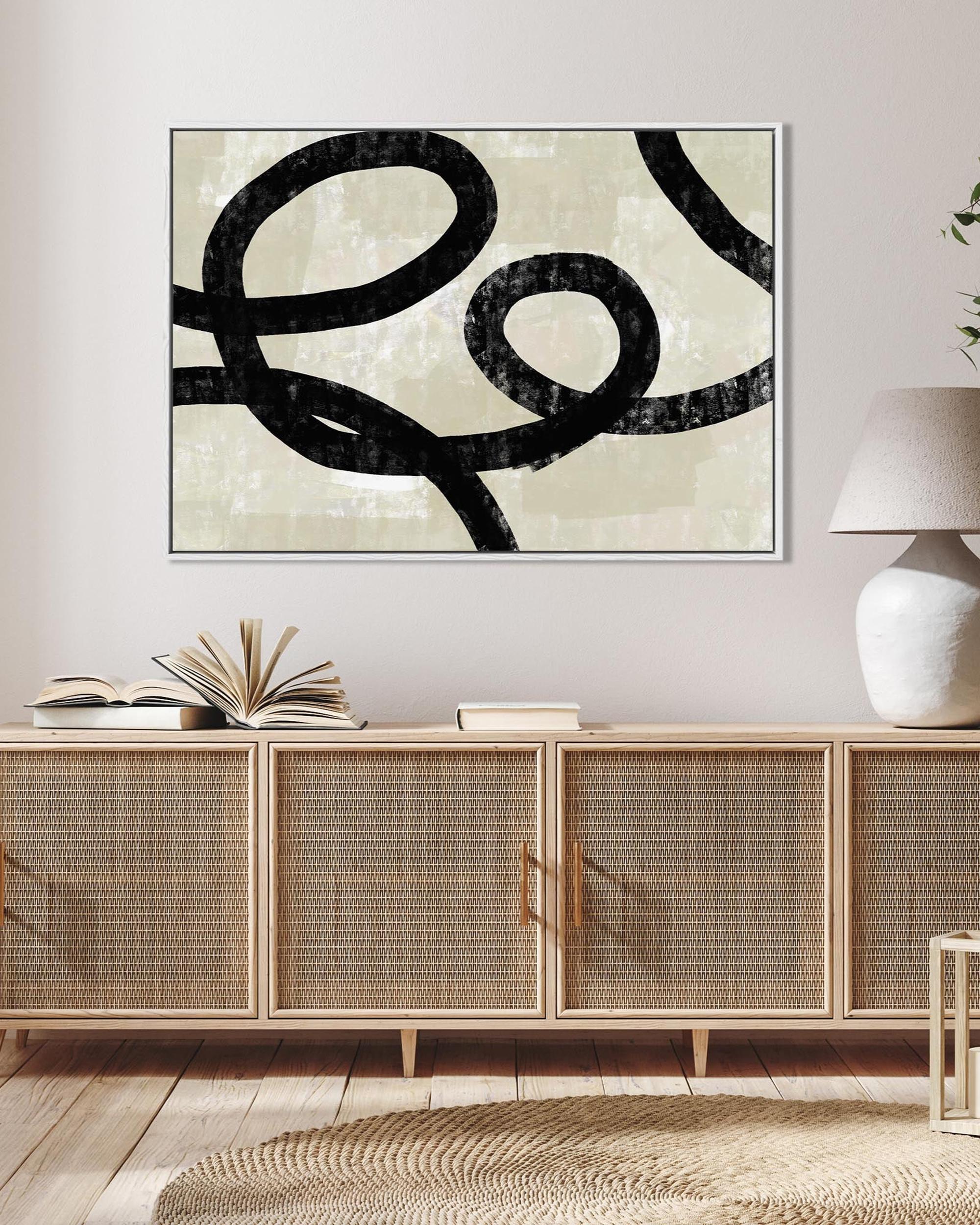Living room with wooden sideboard, abstract art, and decorative items.