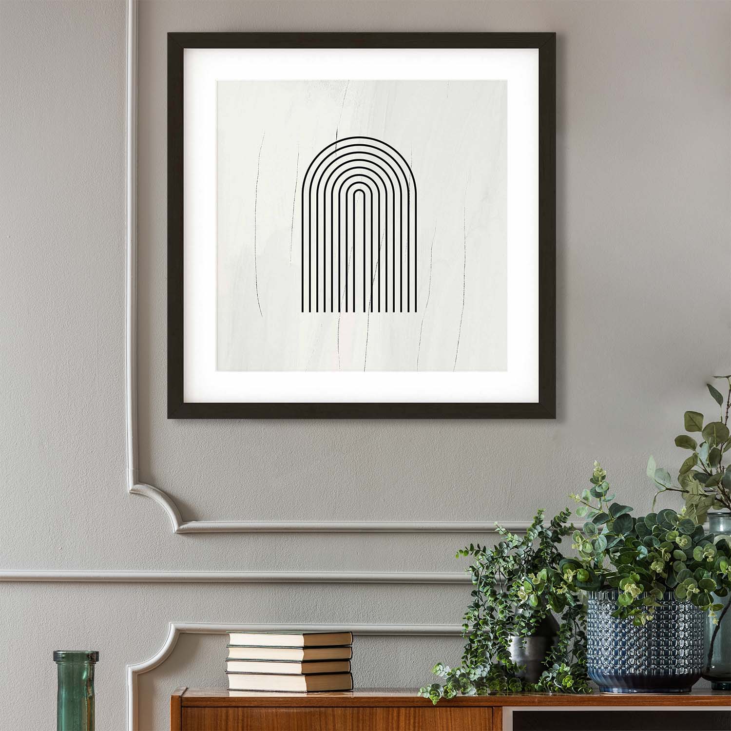 Framed abstract art print on a wall with decorative items below