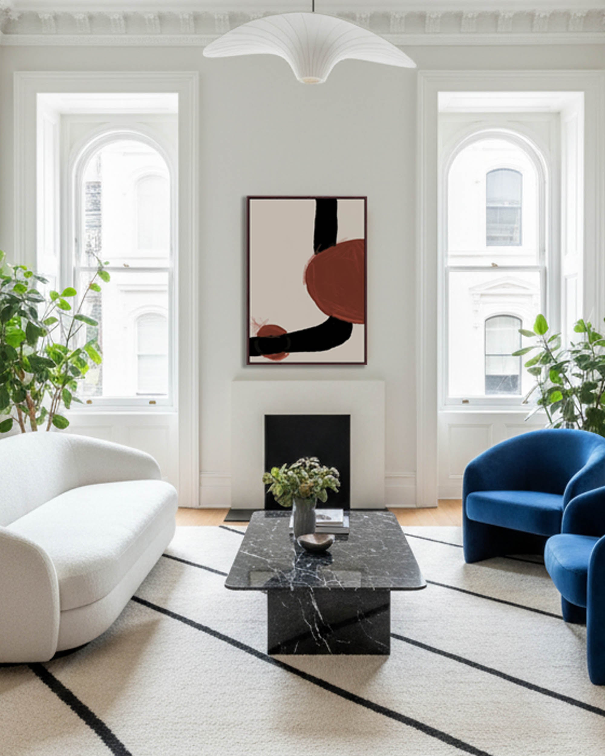 Modern living room with white walls, a marble coffee table, and abstract art.