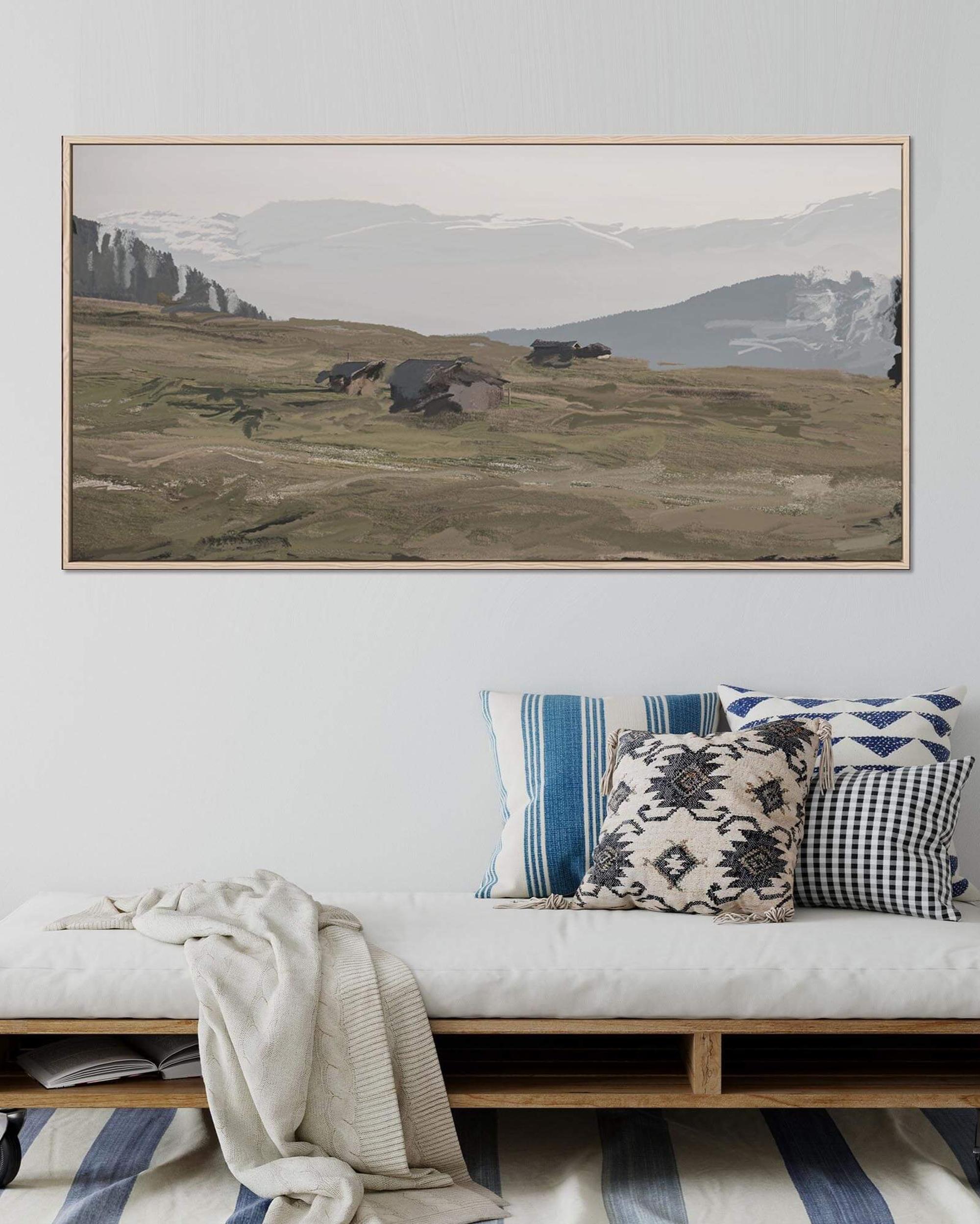 Framed landscape painting above a bench with decorative pillows in a living room setting.