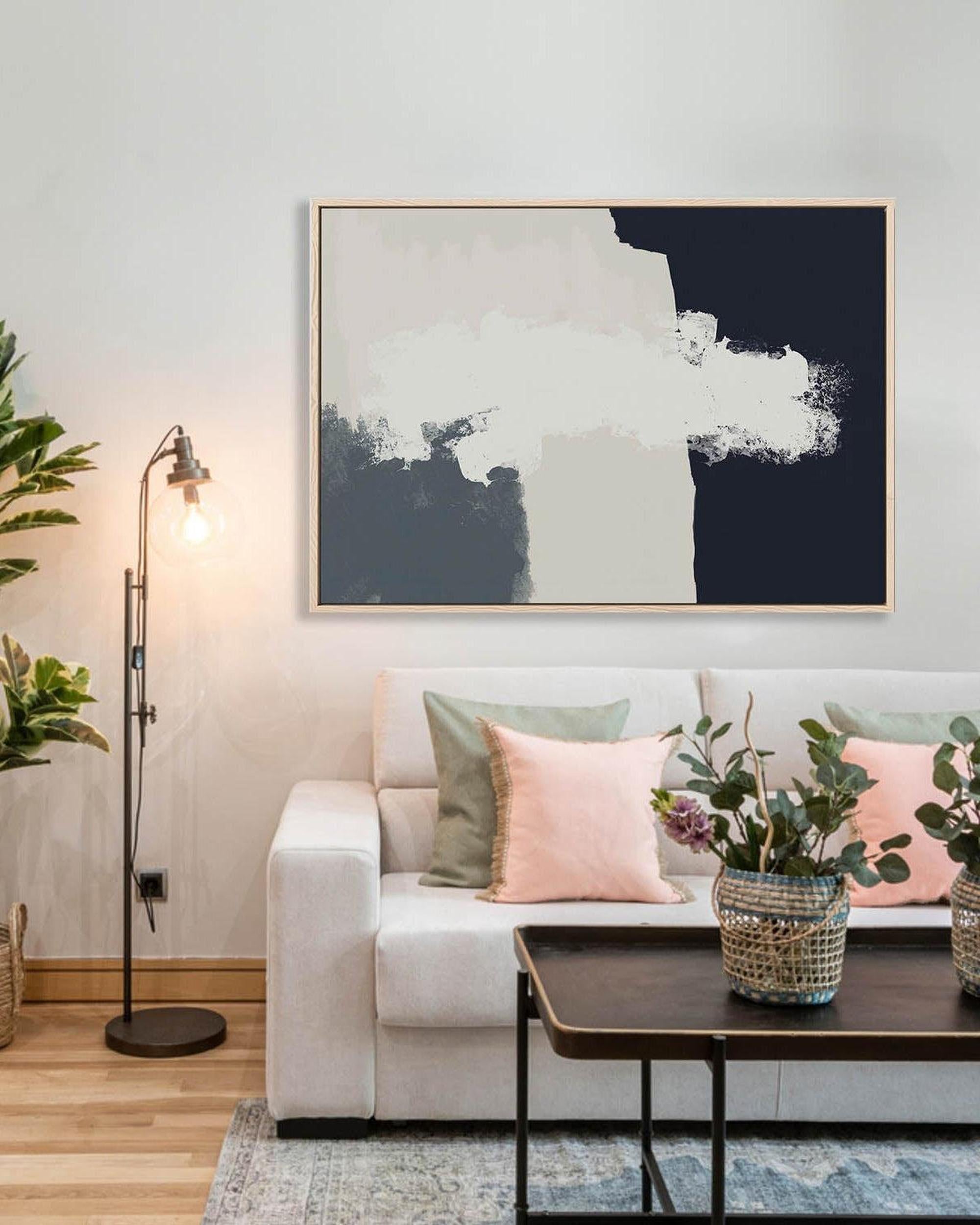Living room with a white sofa, decorative pillows, a coffee table, and a large abstract painting on the wall.