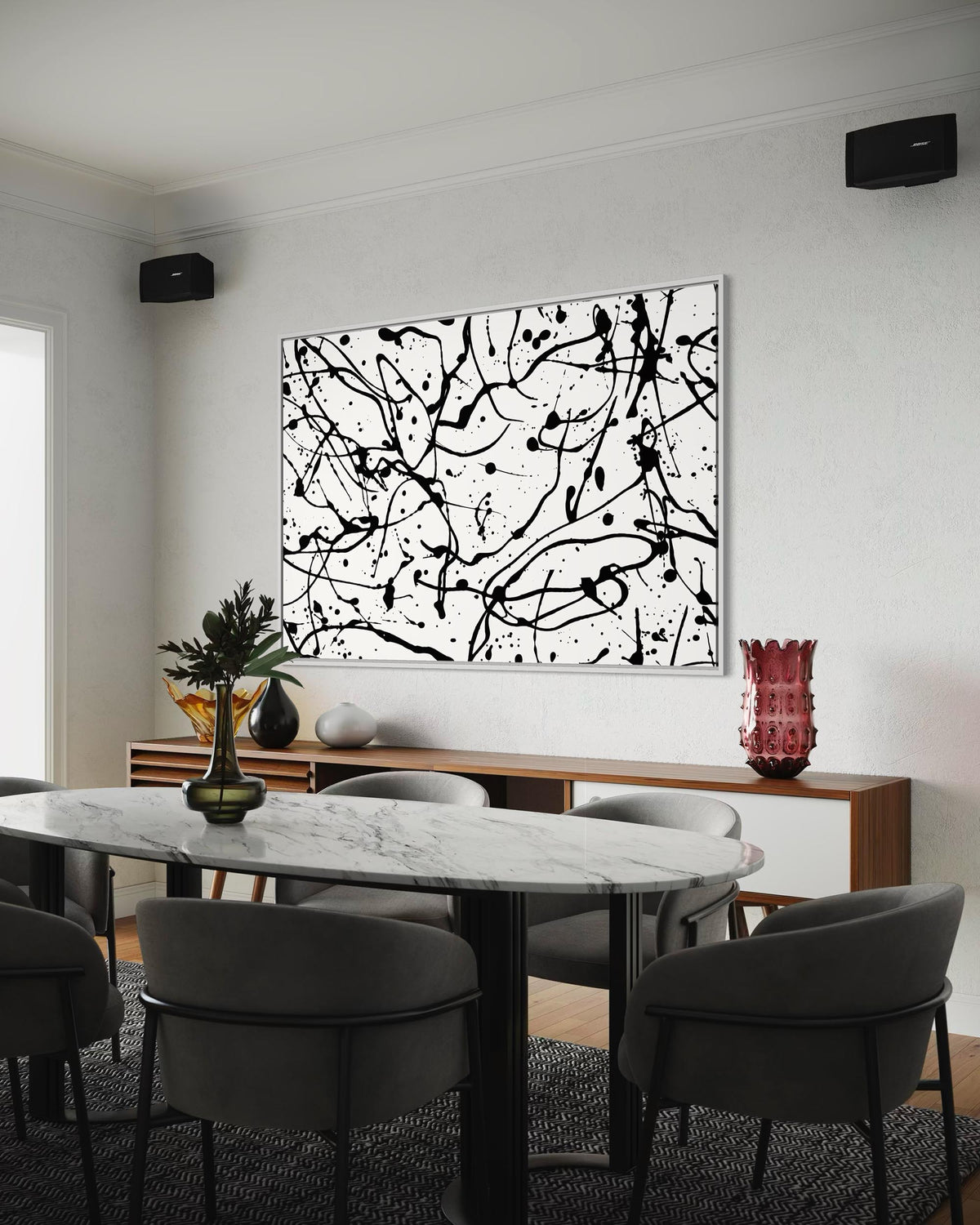 Dining room with a marble table and chairs, abstract black and white painting on the wall, and decorative vases.
