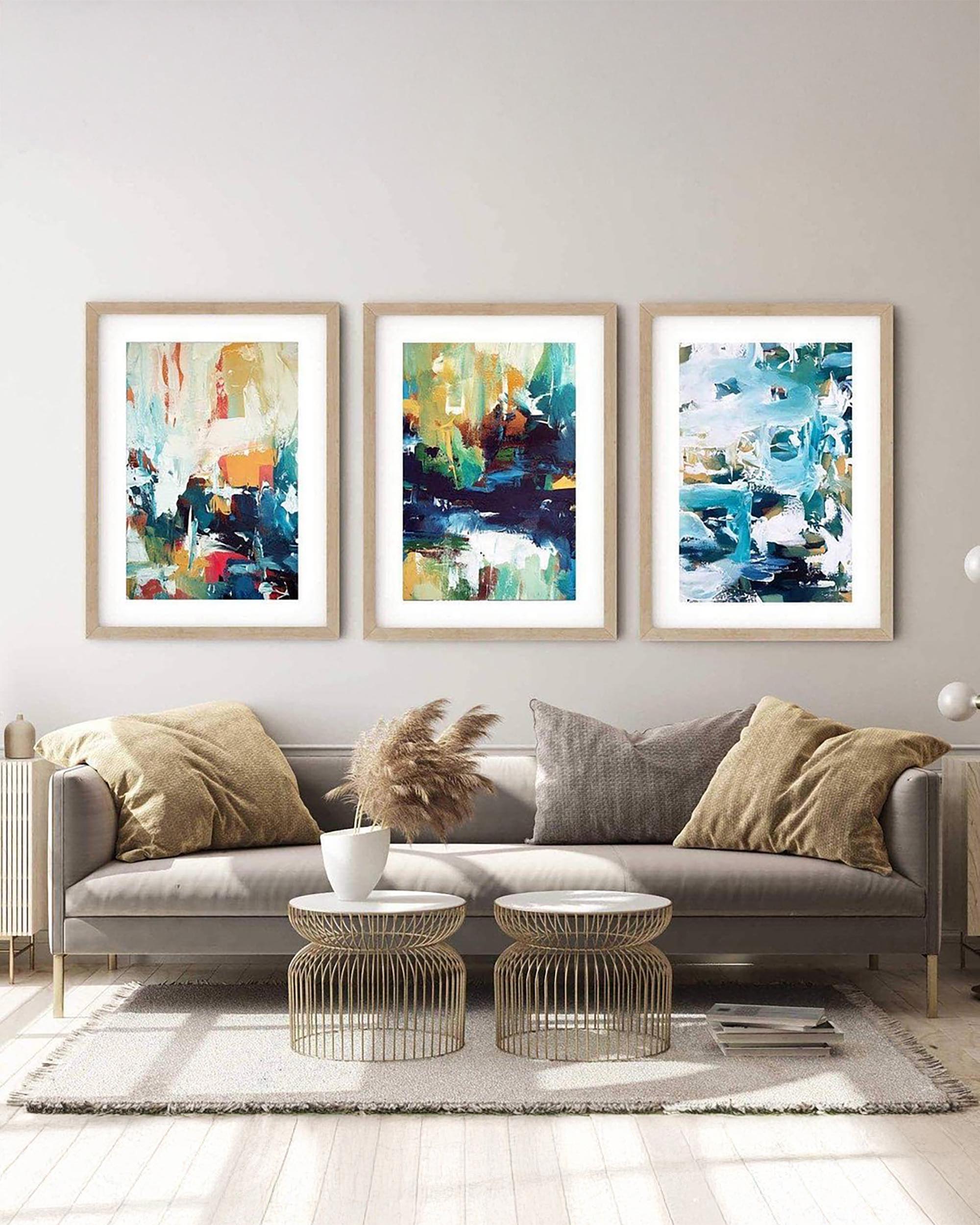 extra large set of 3 abstract prints framed in oak frame above a sofa in modern living room