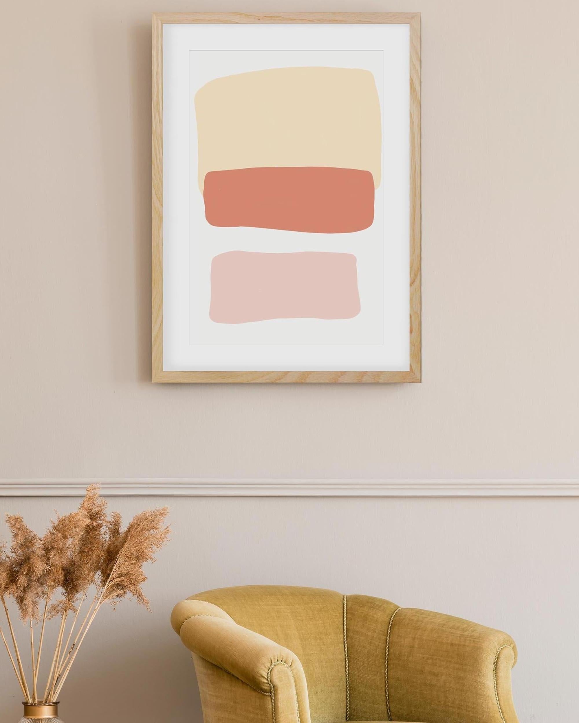 Framed abstract art with geometric shapes on a wall above a yellow armchair.
