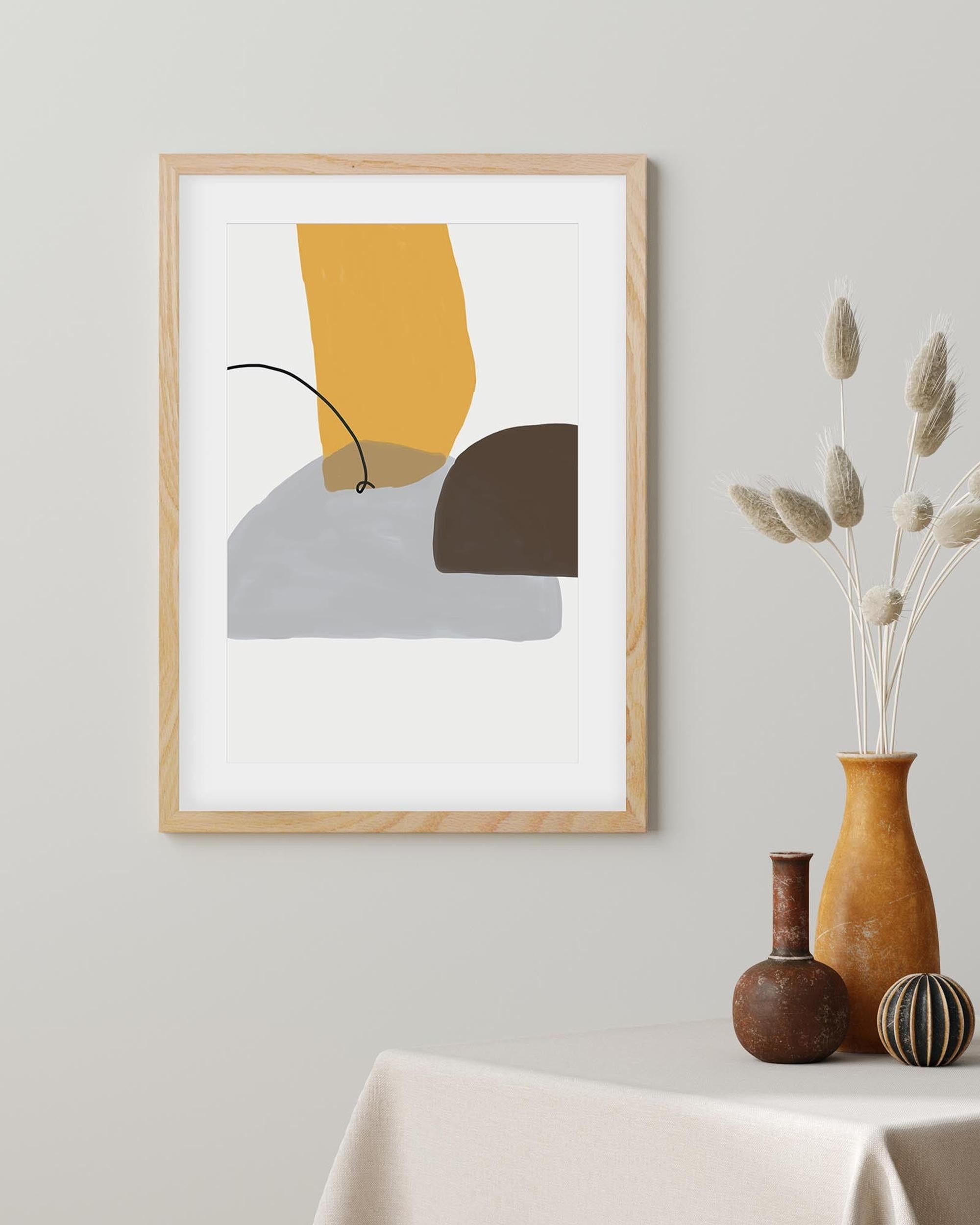 Framed abstract art piece on a wall with decorative vases below.