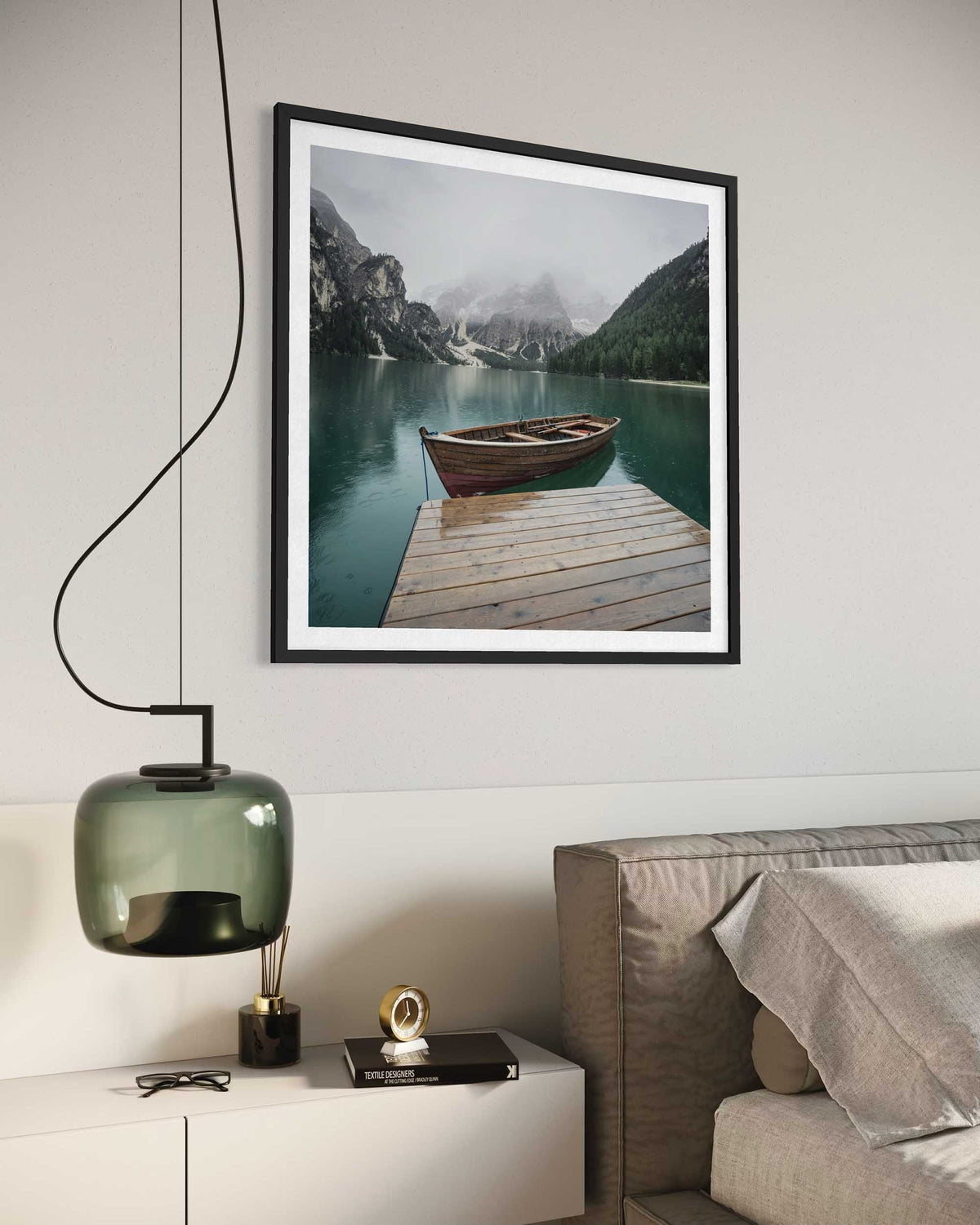 Framed photograph of a lake with a boat on a wooden dock, hanging above a modern bedroom setup.
