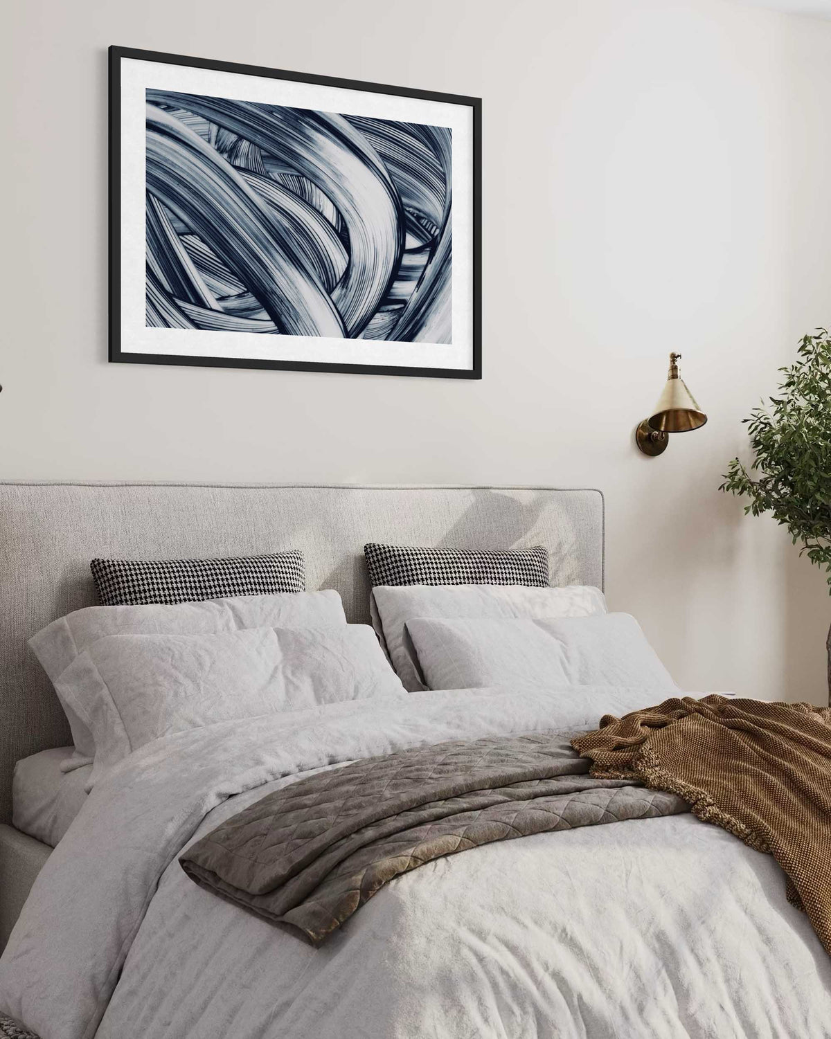 Framed abstract art above a bed in a bedroom setting