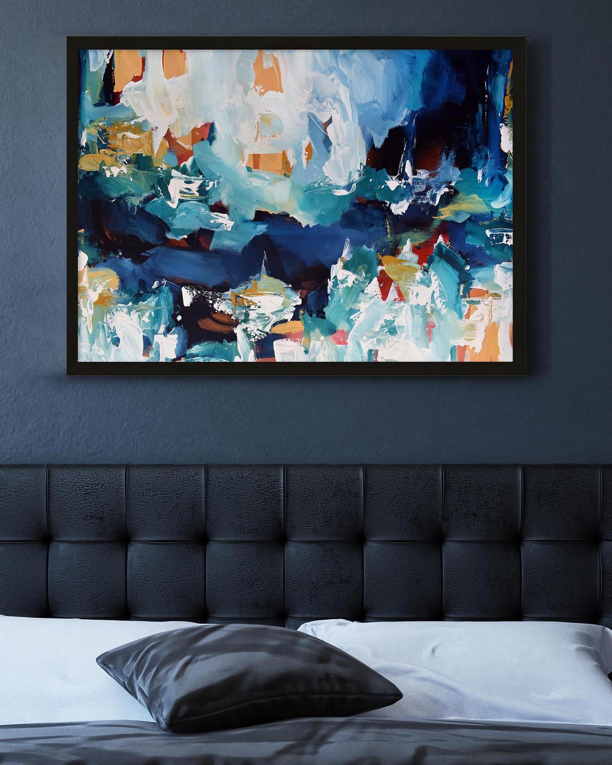 Abstract painting on a wall above a bed with a dark headboard