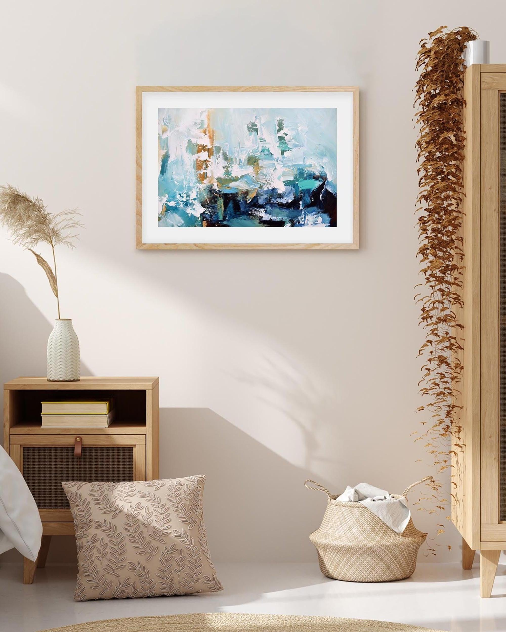 Framed abstract art piece on a wall with decorative elements in a room.