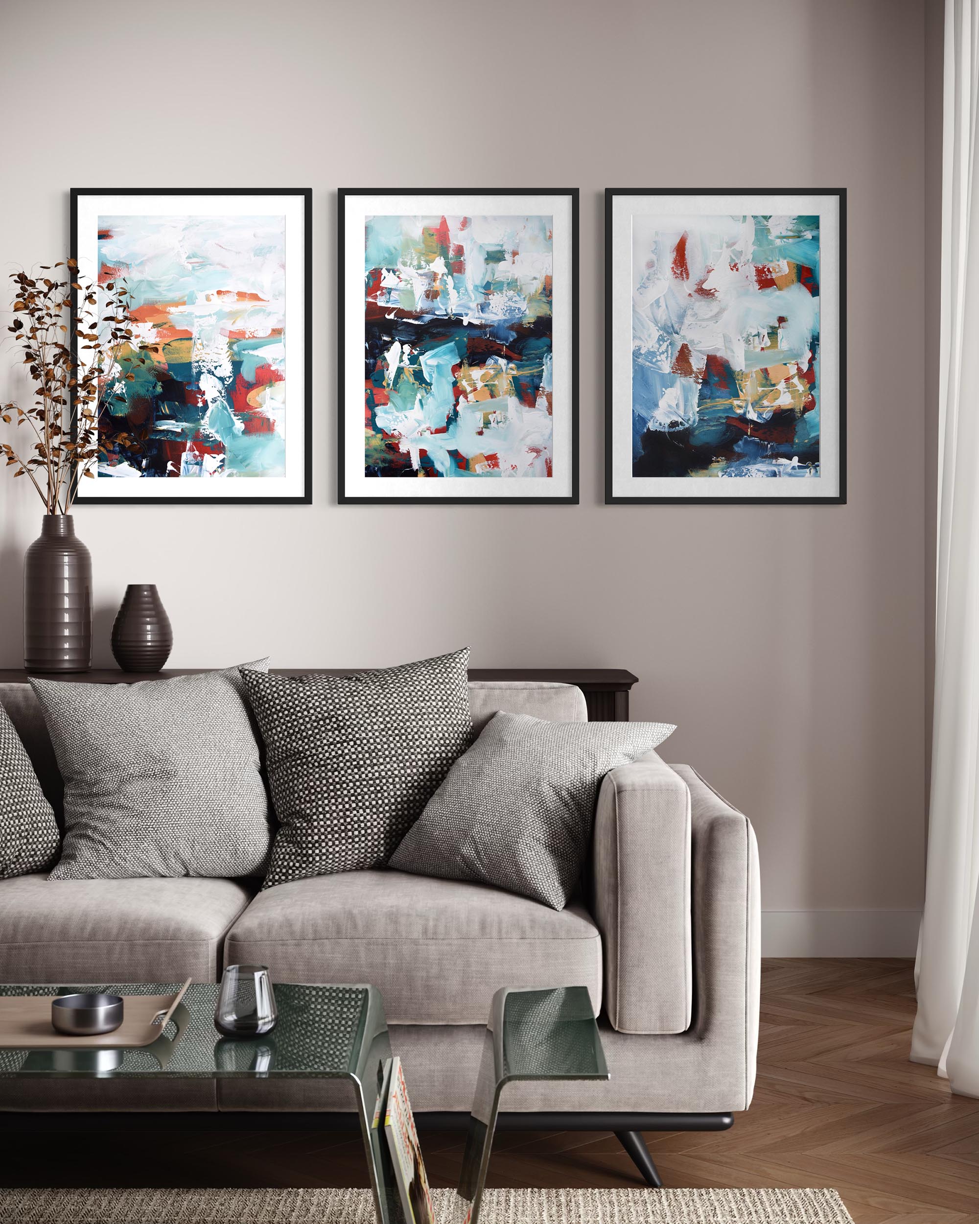Gray sofa with decorative pillows in a living room with abstract art on the wall.