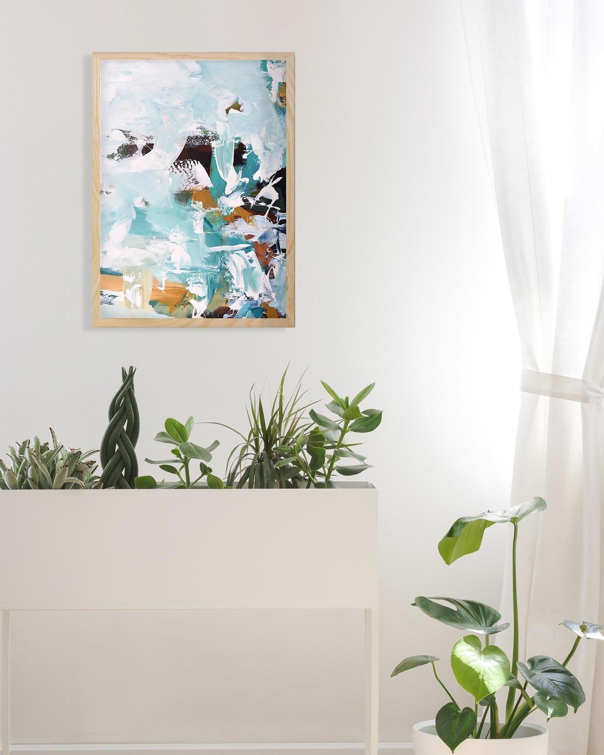Abstract art print on a wall with plants below