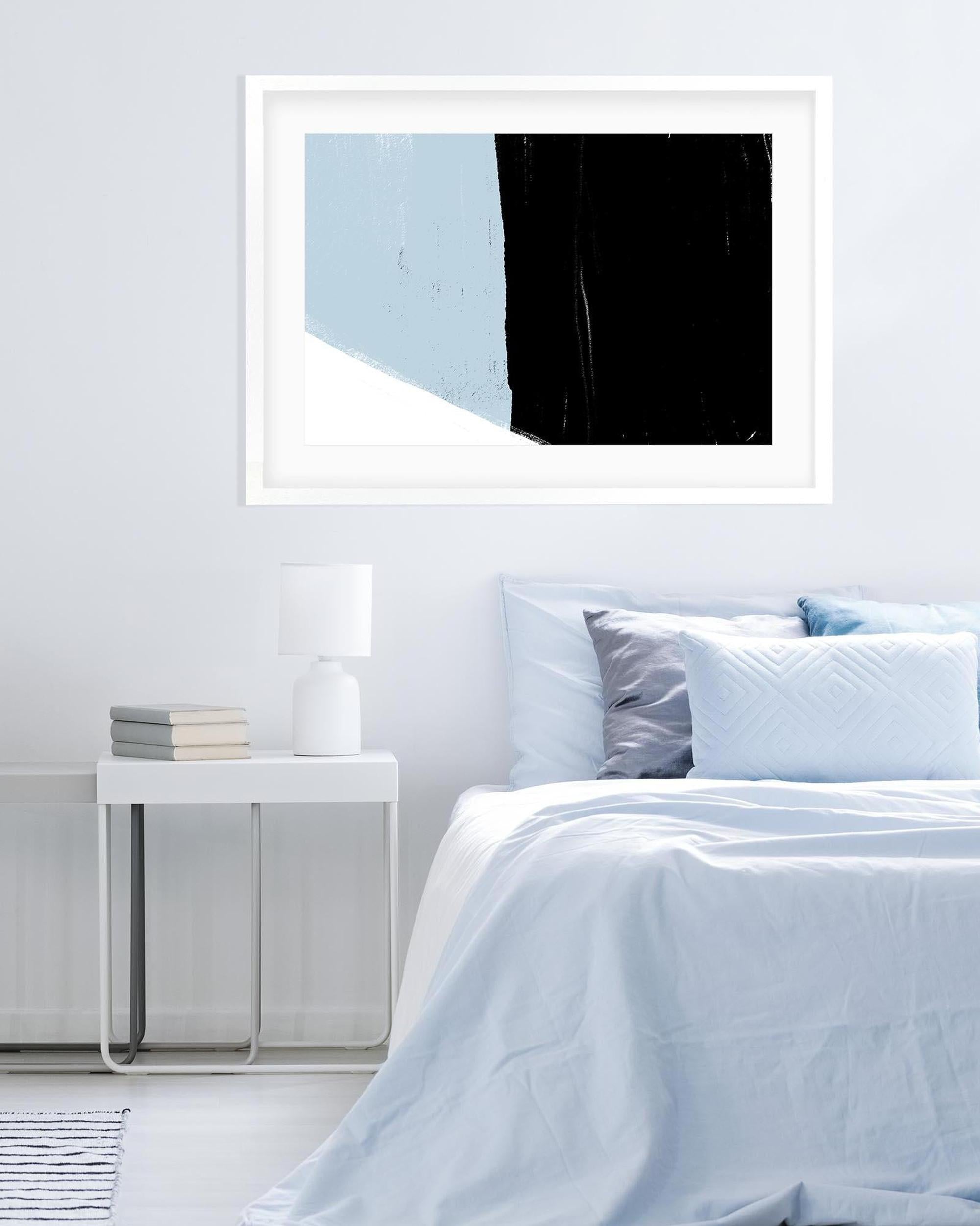 Framed abstract art above a bed in a bedroom setting
