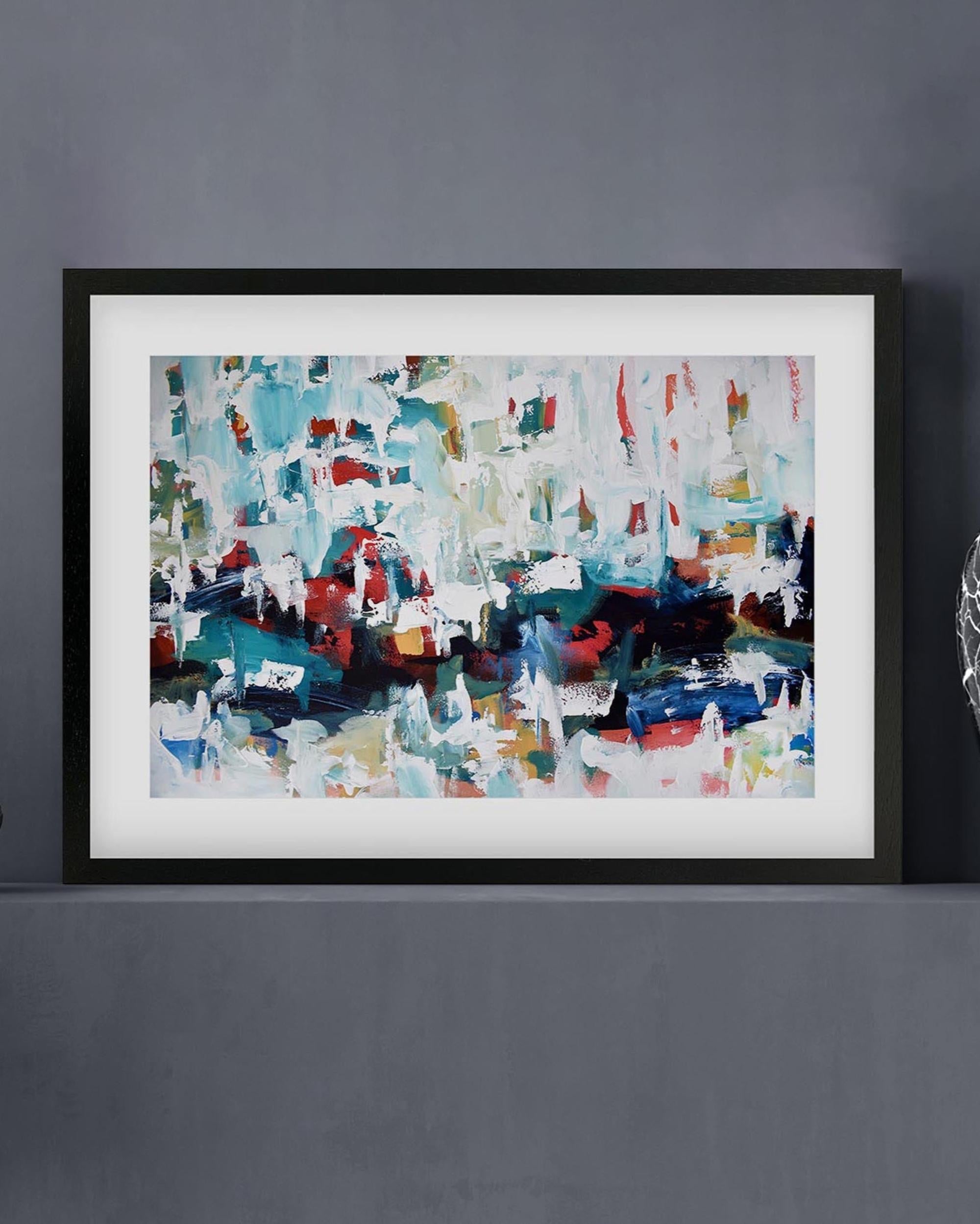 Framed abstract painting with multicolors on a gray wall