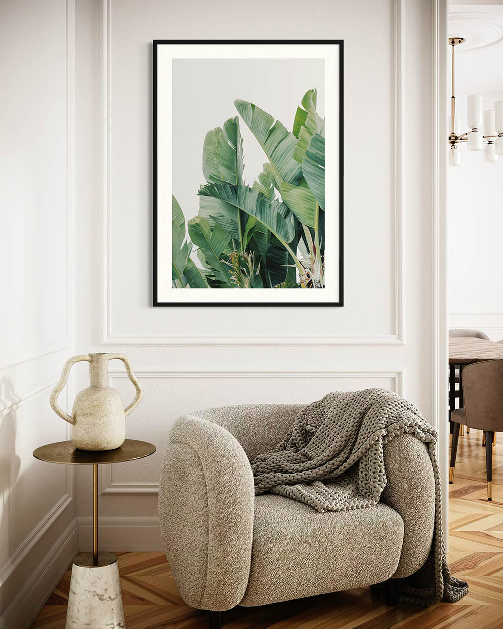 Framed botanical plant print above a cozy armchair in a living room.