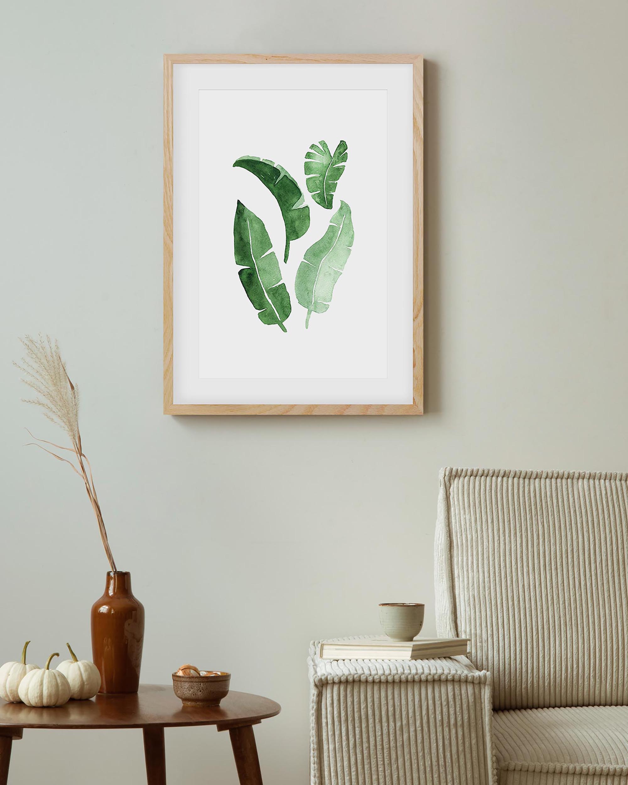 green botanical leaves art print in an oak frame in a modern living room