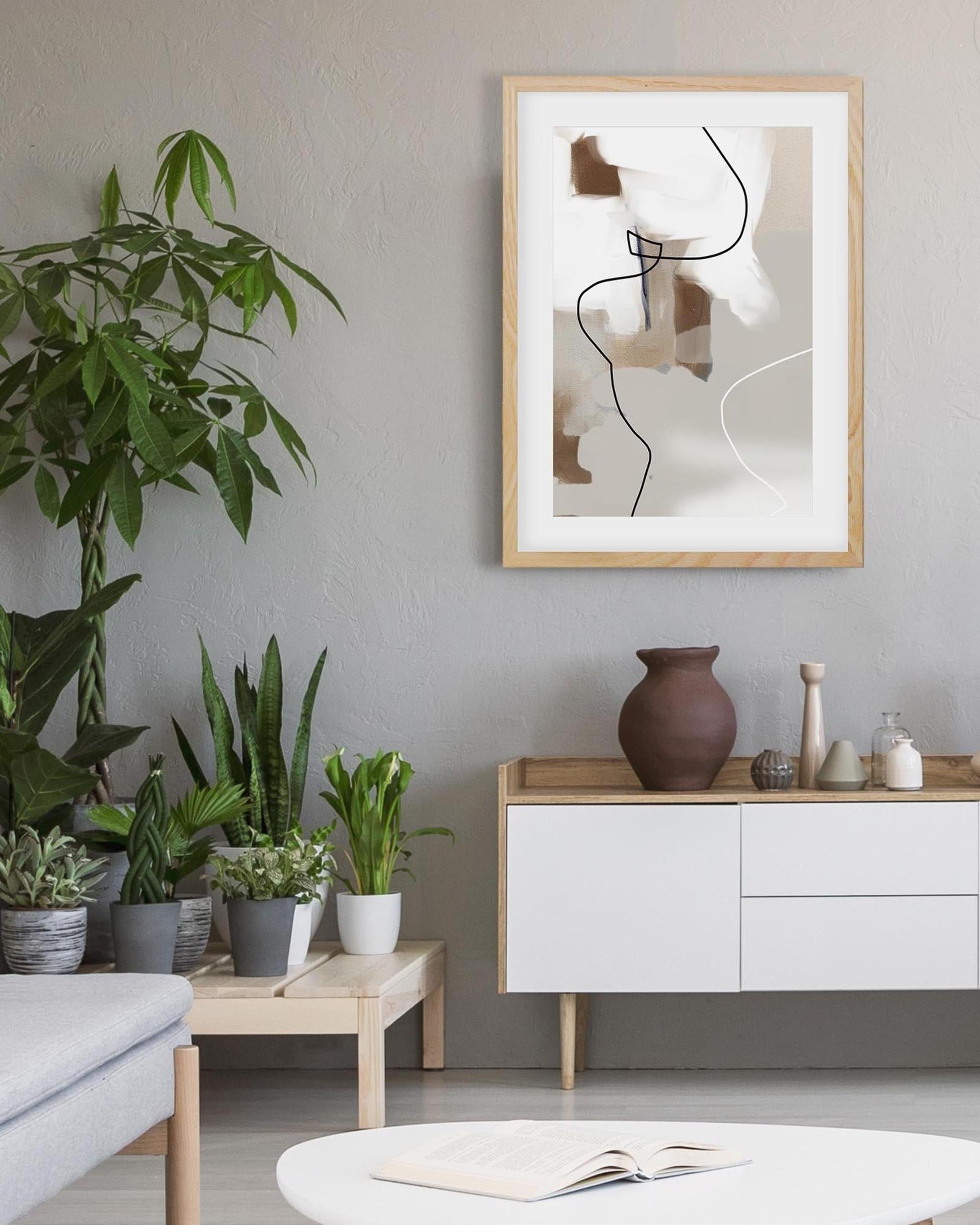 Modern living room with plants, a vase, and abstract art on the wall.