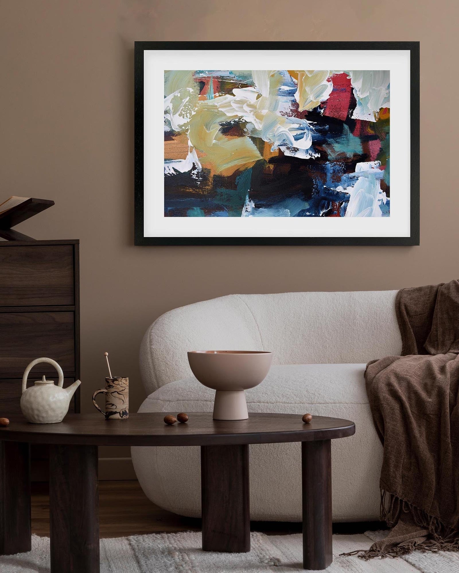 Abstract painting on a wall above a sofa in a living room setting.