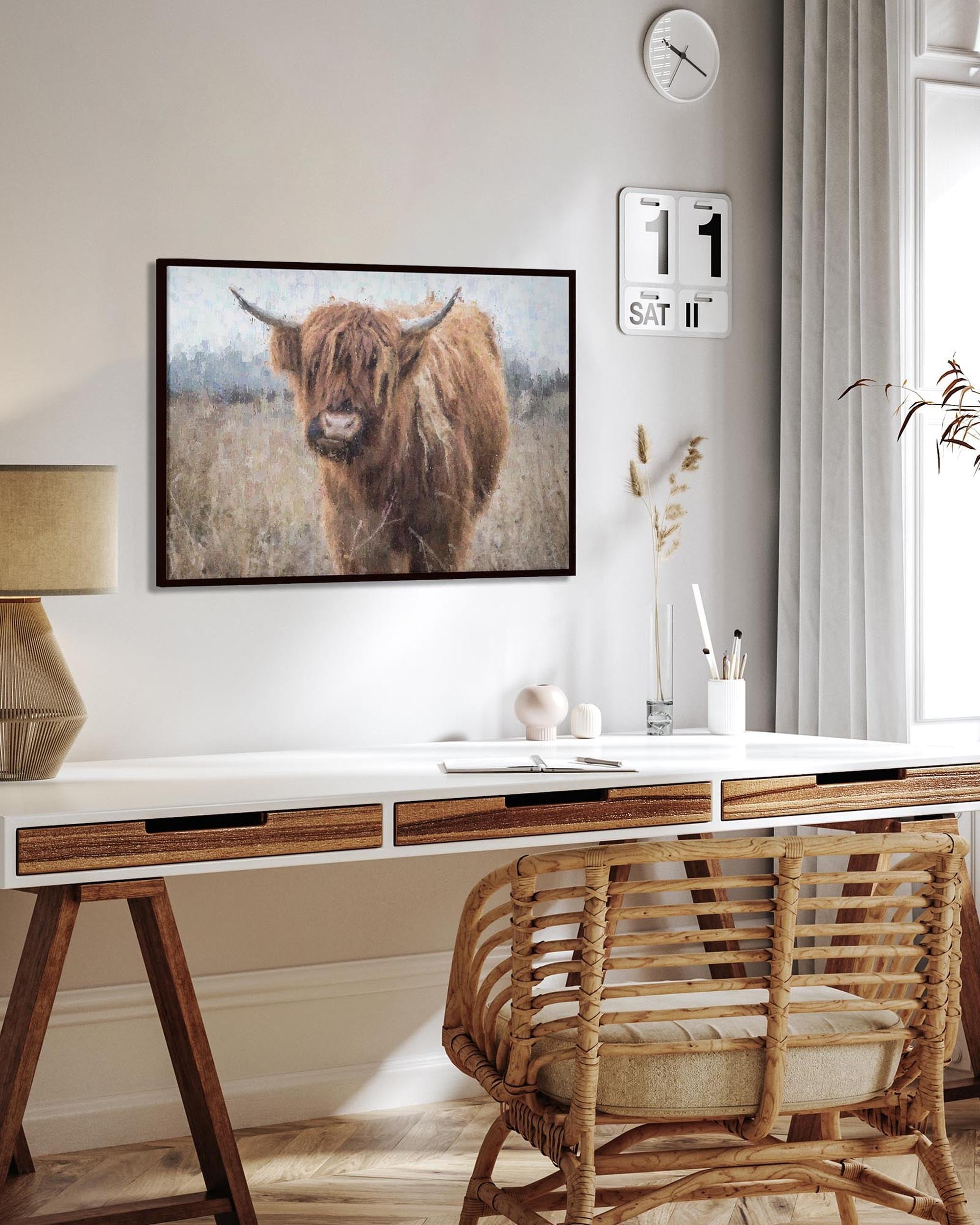 Modern home office with a desk, chair, and wall art of a highland cow.