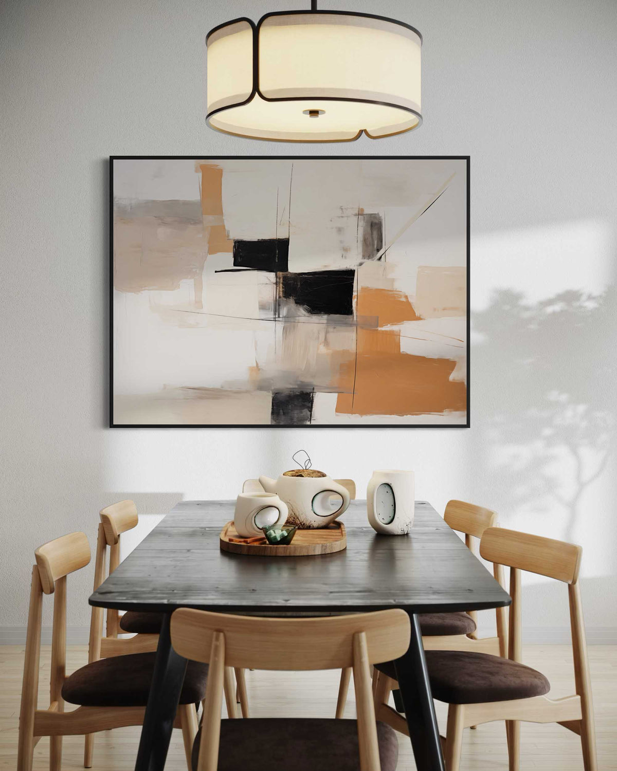 Dining room with a black table and wooden chairs, abstract art on the wall, and a chandelier.