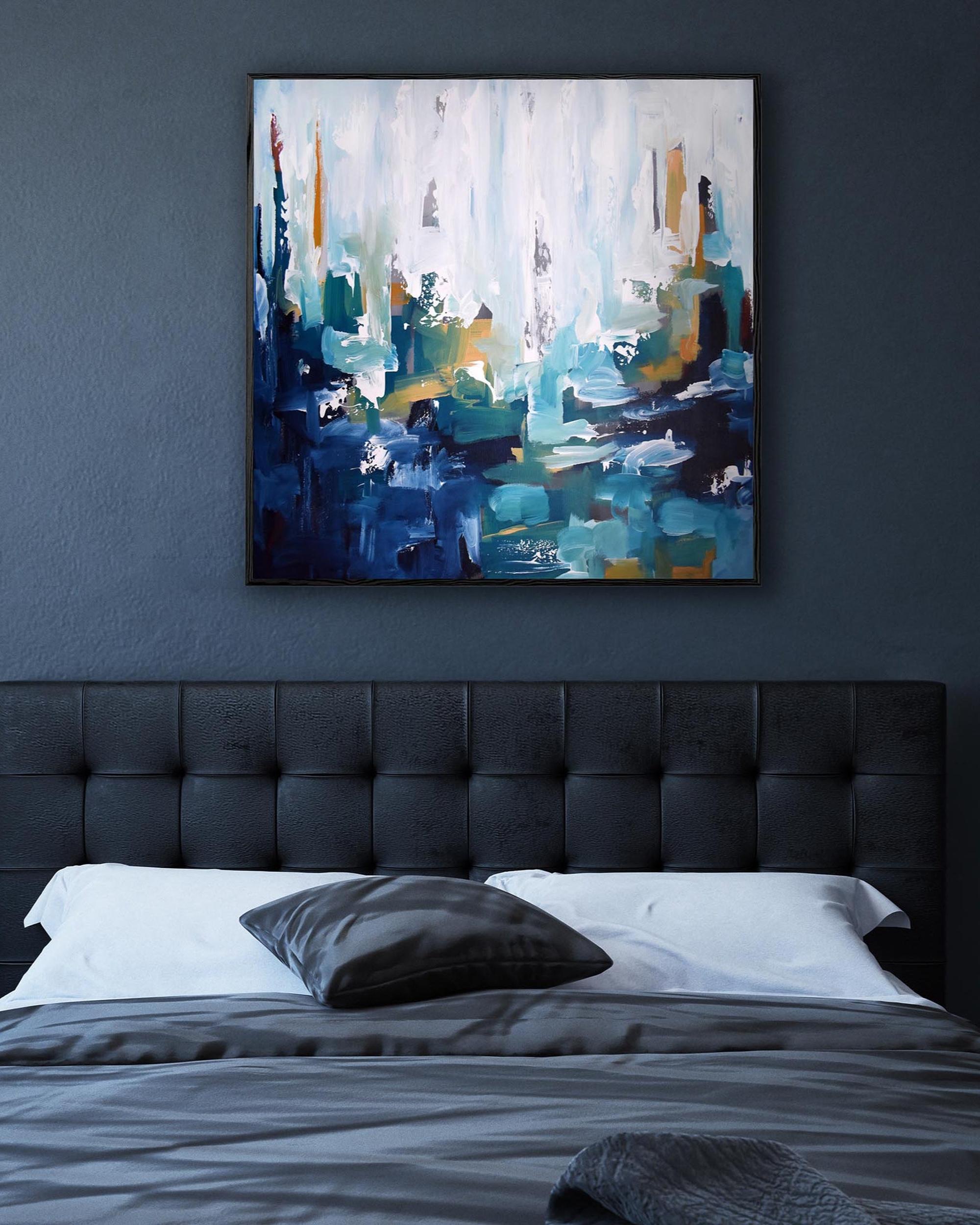 Abstract painting on a dark wall above a bed with a tufted headboard.