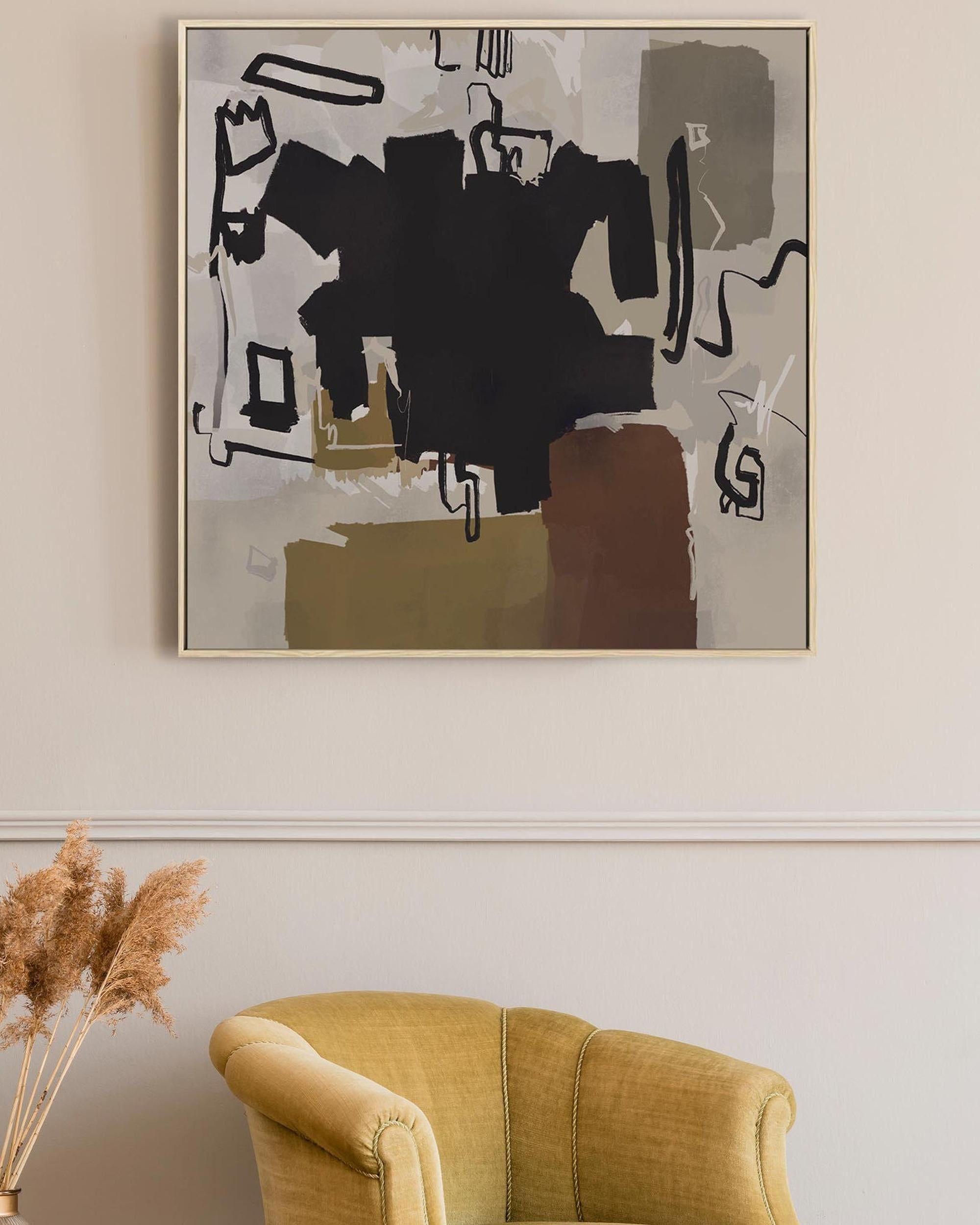 Abstract black and white painting on a beige wall above a mustard yellow armchair.
